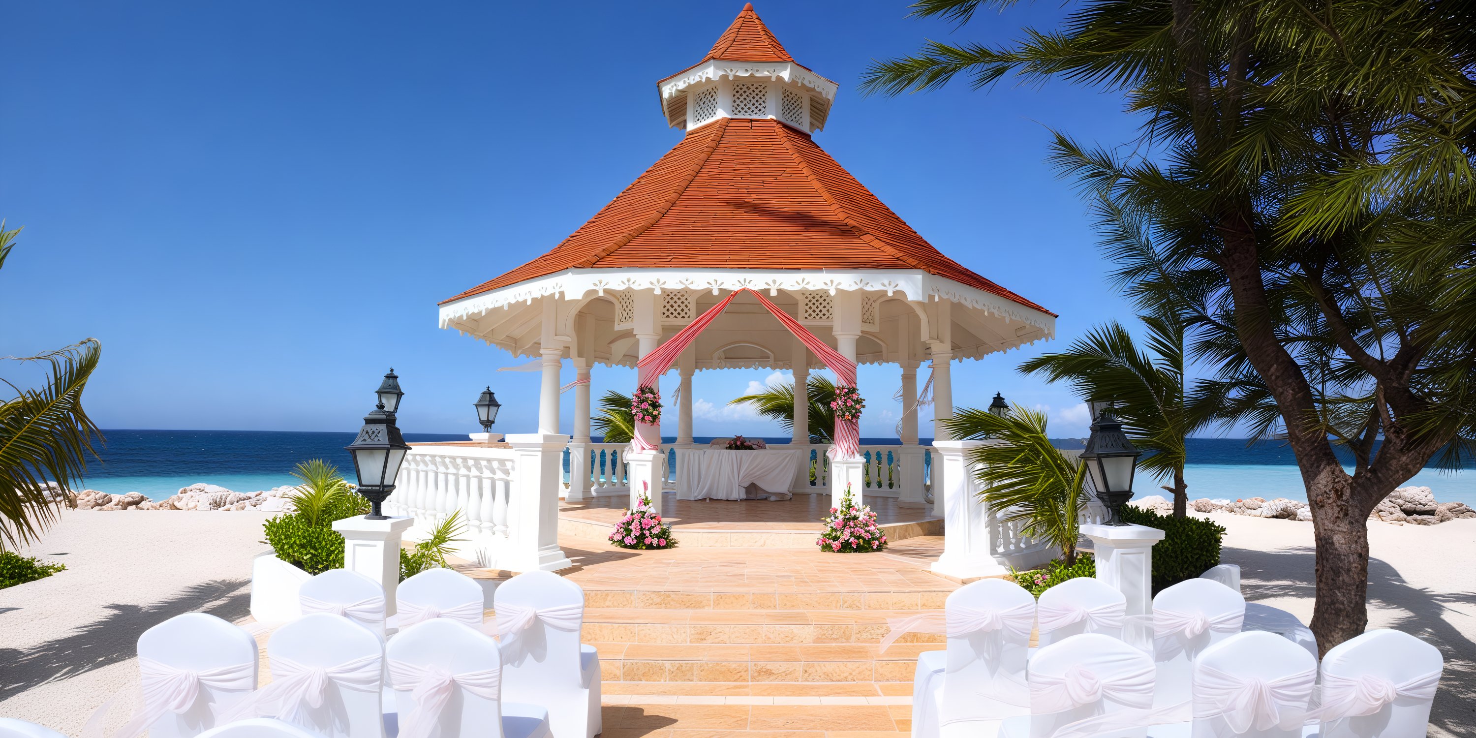 A beachfront gazebo designed for a destination wedding, adorned with chairs, floral decorations, and offering a stunning ocean view.
