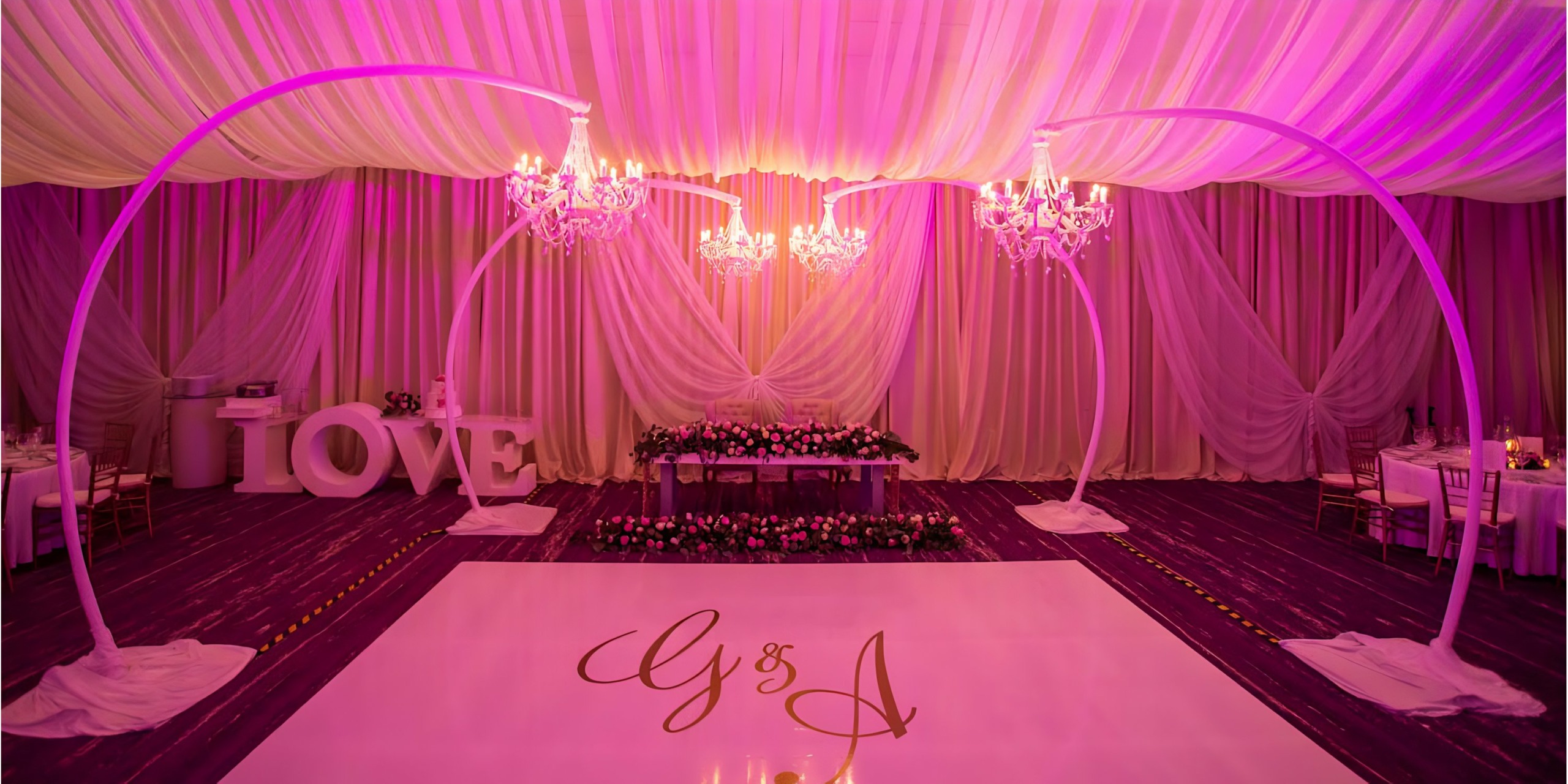 A wedding reception at Breathless Riviera Cancún Resort & Spa with a white floor and chandeliers.