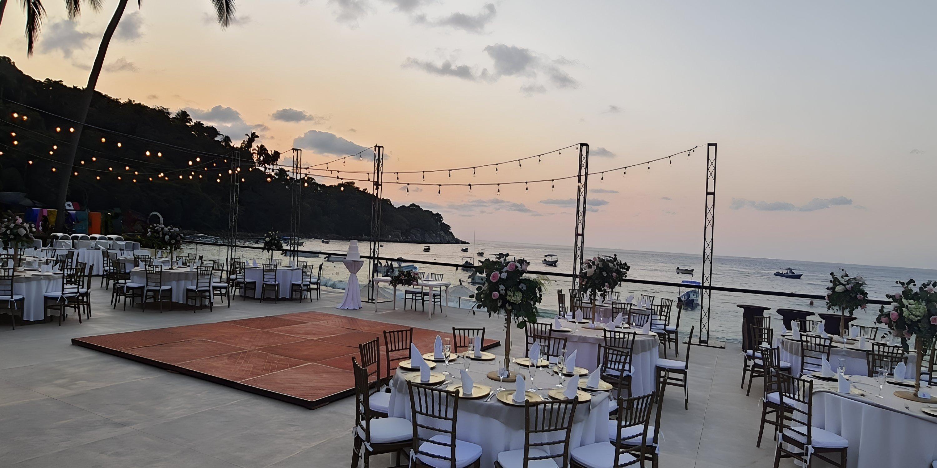Barcelo Puerto Vallarta: destination wedding venue by the sea with round tables, string lights, sunset dance floor.