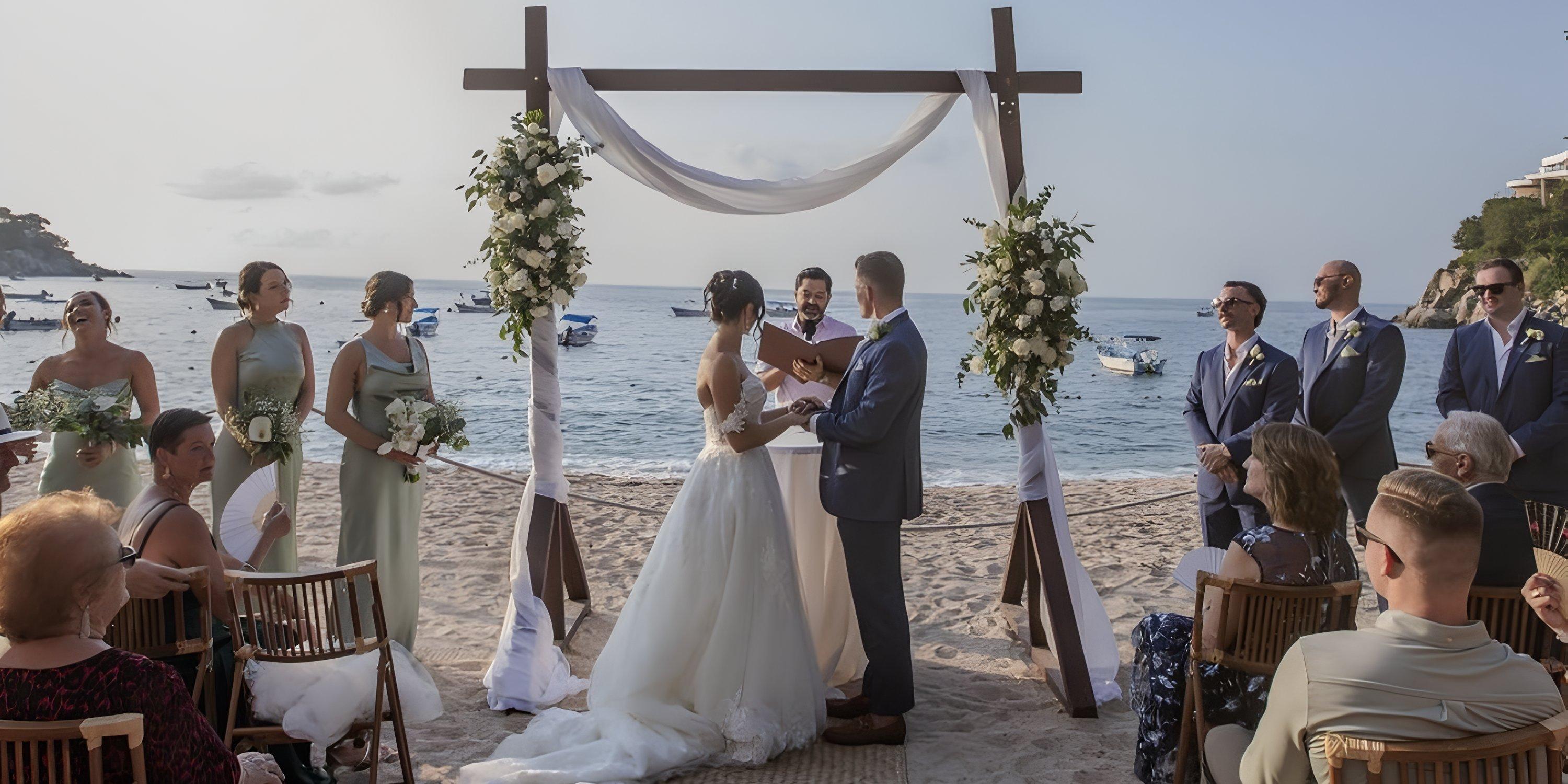 A destination wedding couple exchanges vows beneath a floral arch at Barcelo Puerto Vallarta, guests looking on.