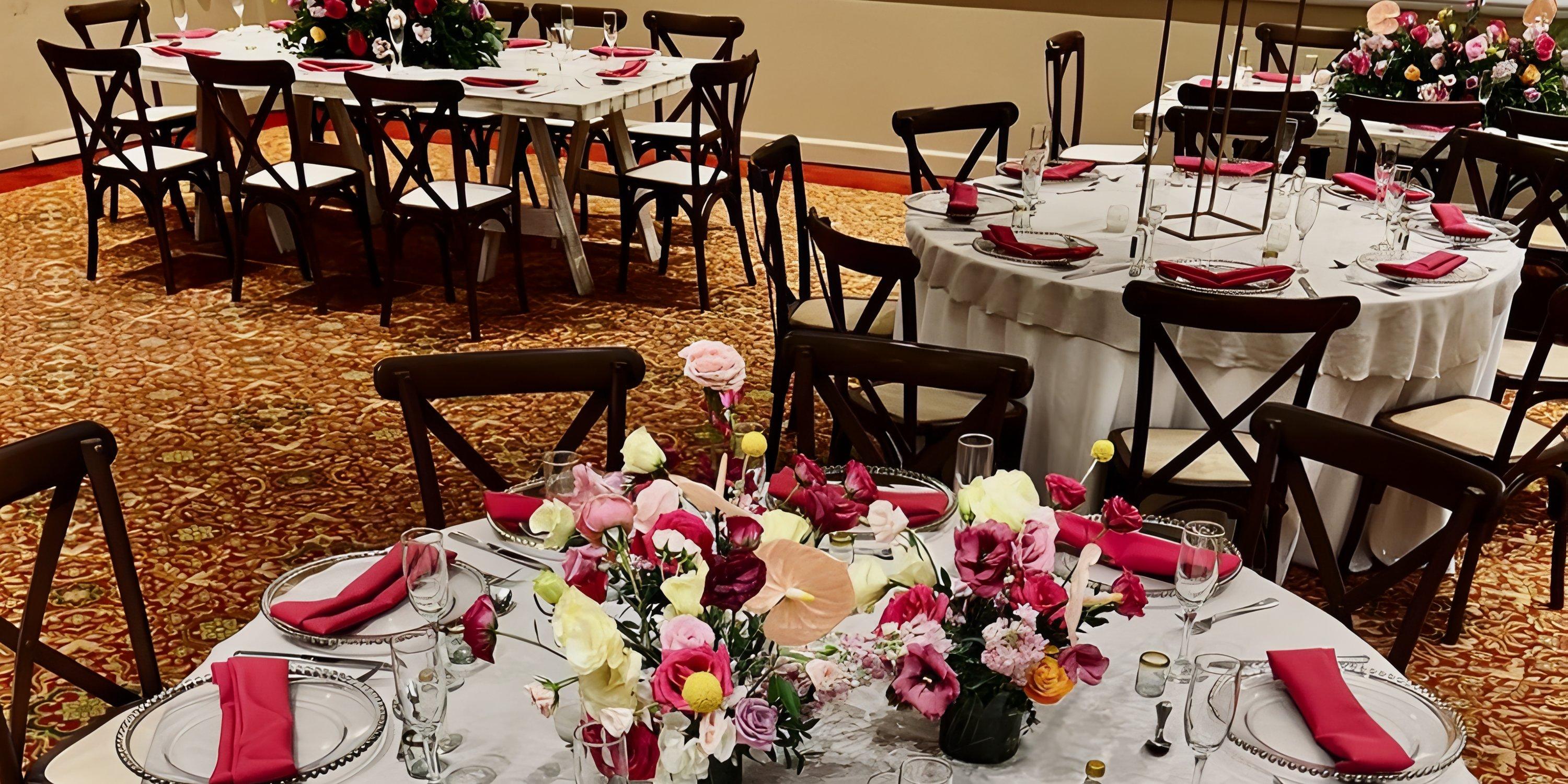 Barcelo Puerto Vallarta destination wedding with round tables, pink floral centerpieces, and napkins.