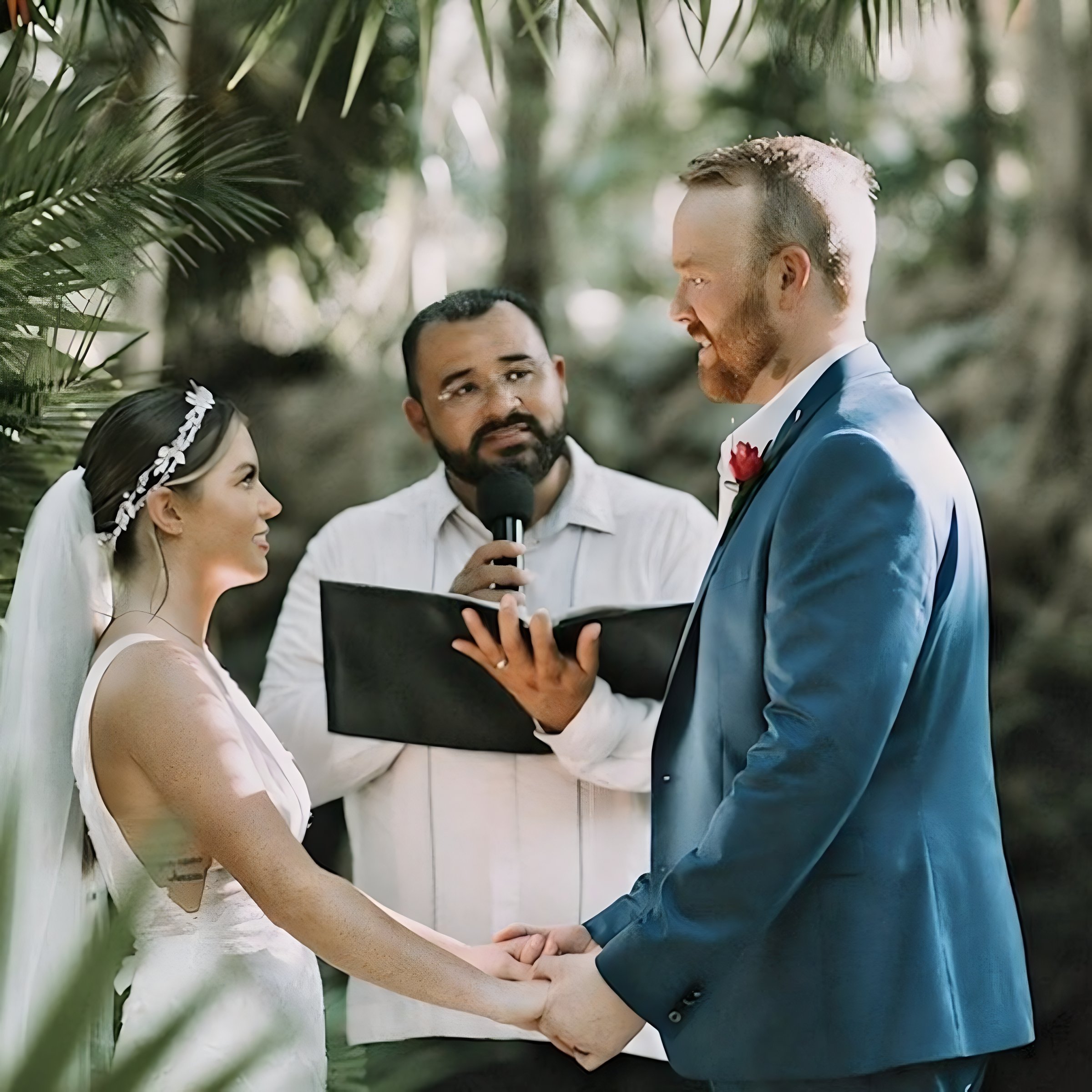Happy couple giving their vows before an officiant at a destination wedding in a lush garden venue