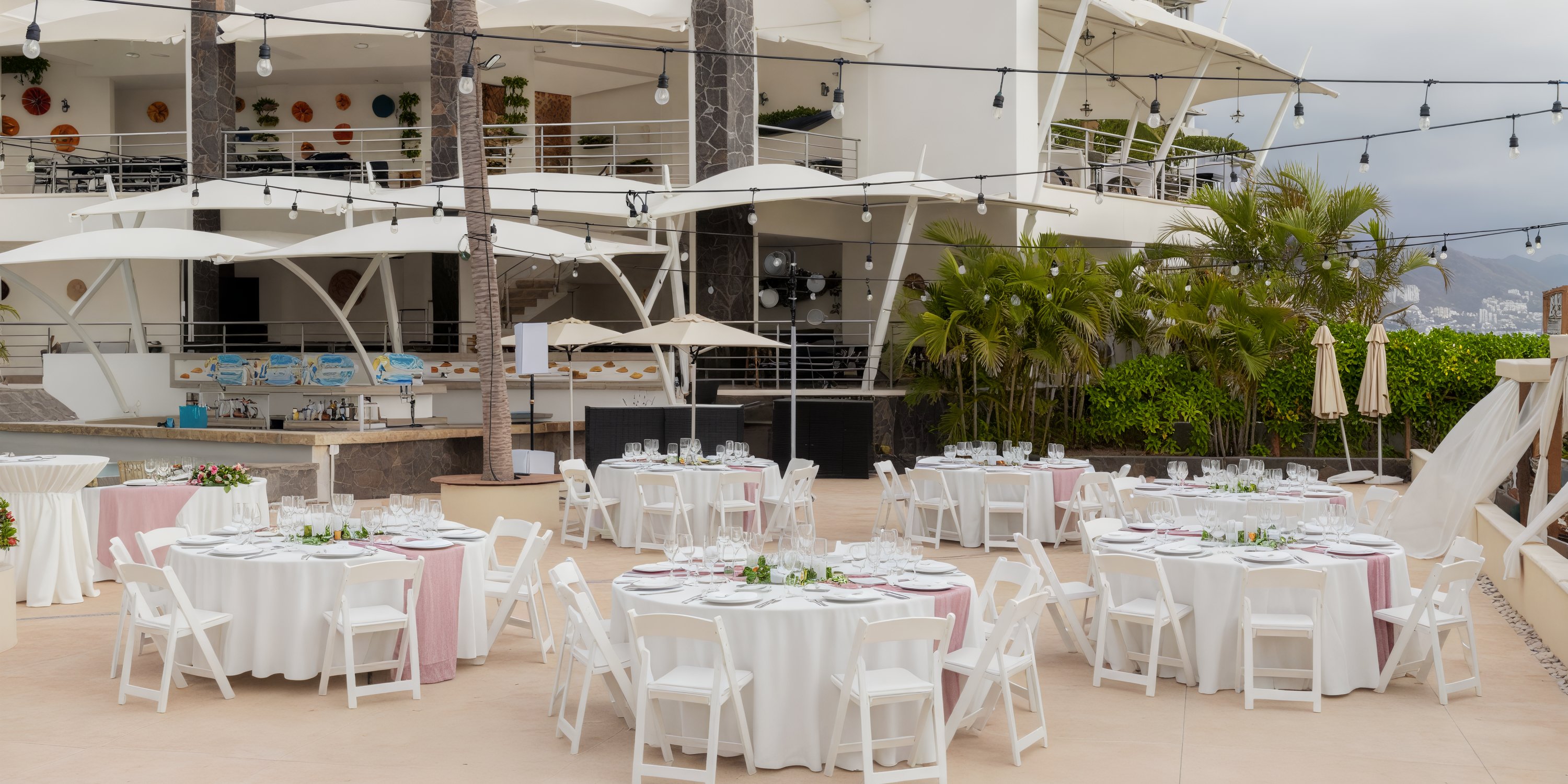 Dreams Vallarta Bay setup features round tables beautifully arranged for an enchanting outdoor destination wedding.