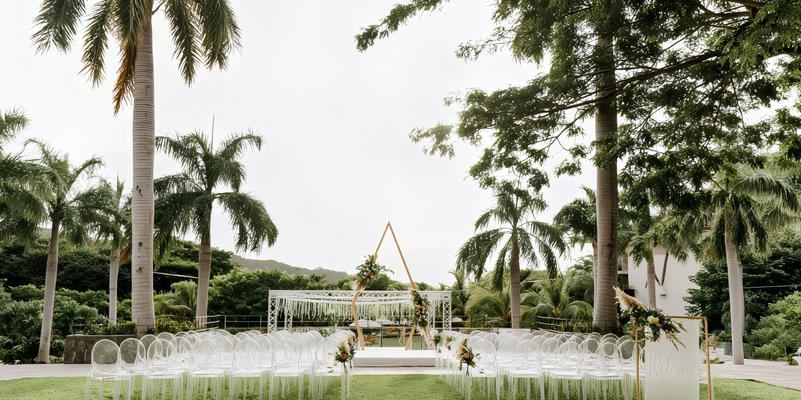 Dreams Las Mareas offers an ideal setting for a destination wedding, featuring an outdoor ceremony with elegant white chairs, swaying palm trees, and a stunning triangular arch.