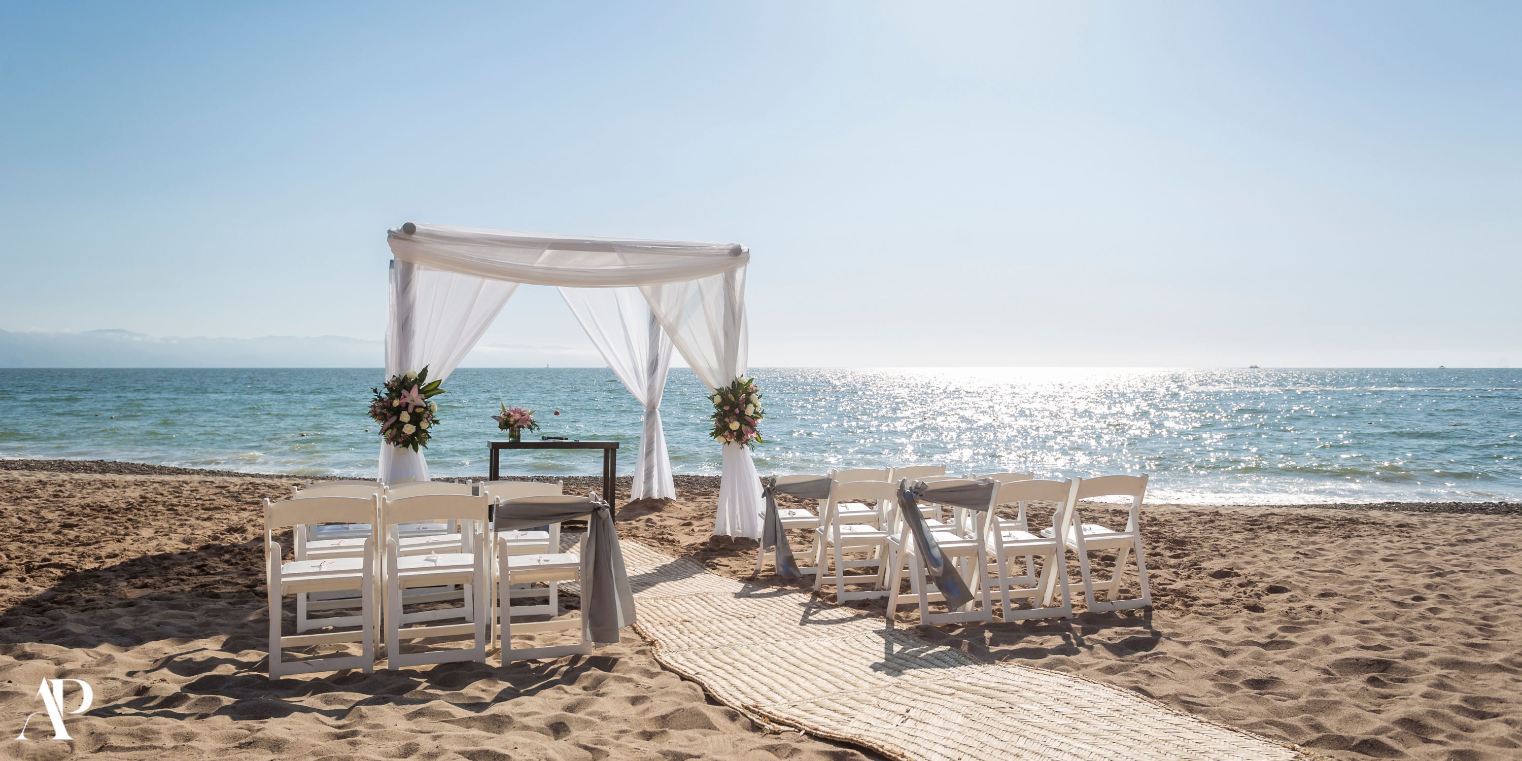 Destination wedding setup at Dreams Vallarta Bay: white chairs and canopy facing the ocean.
