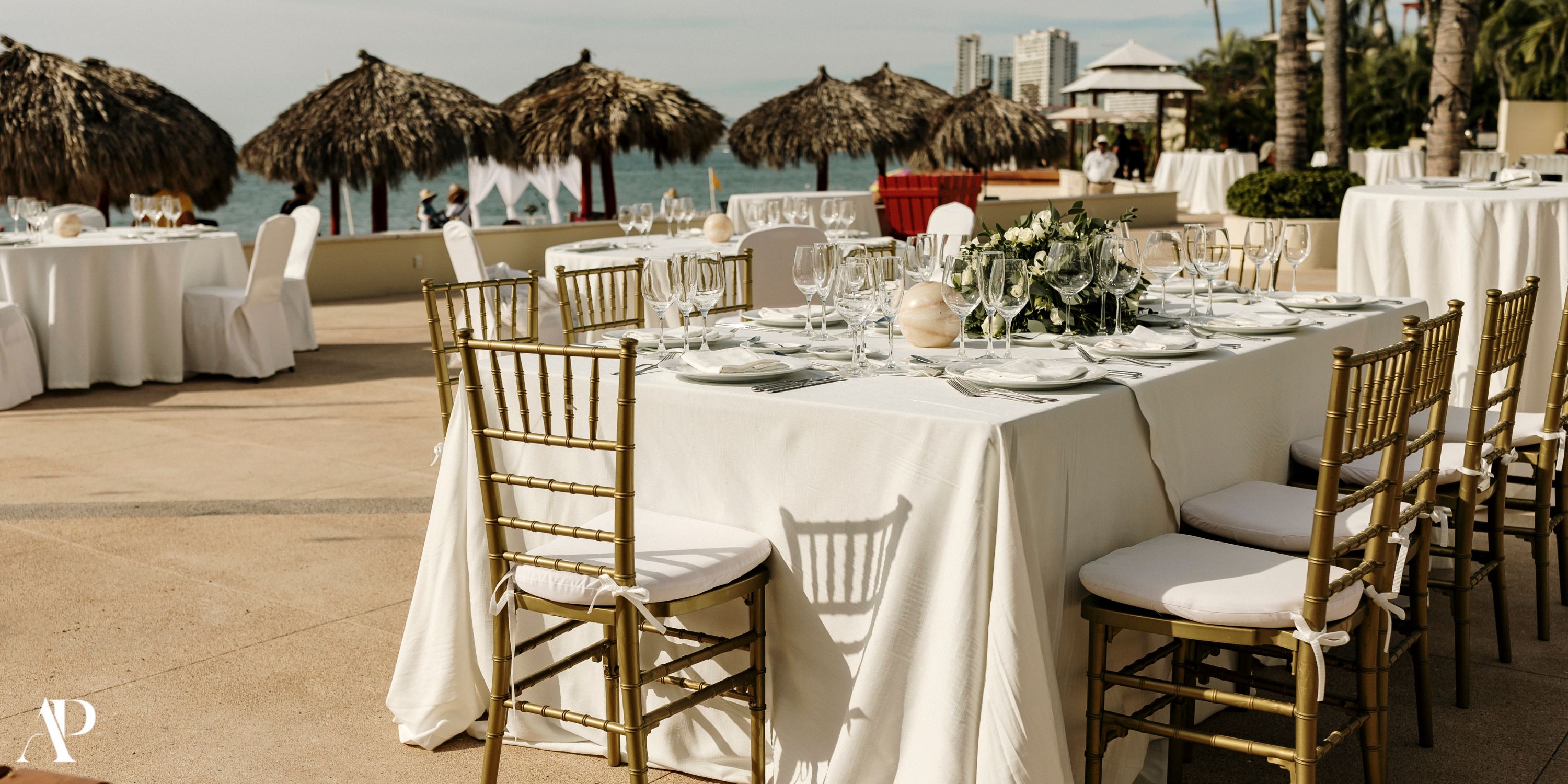 Destination wedding banquet at Dreams Vallarta Bay with white linens, gold chairs, and an ocean view.