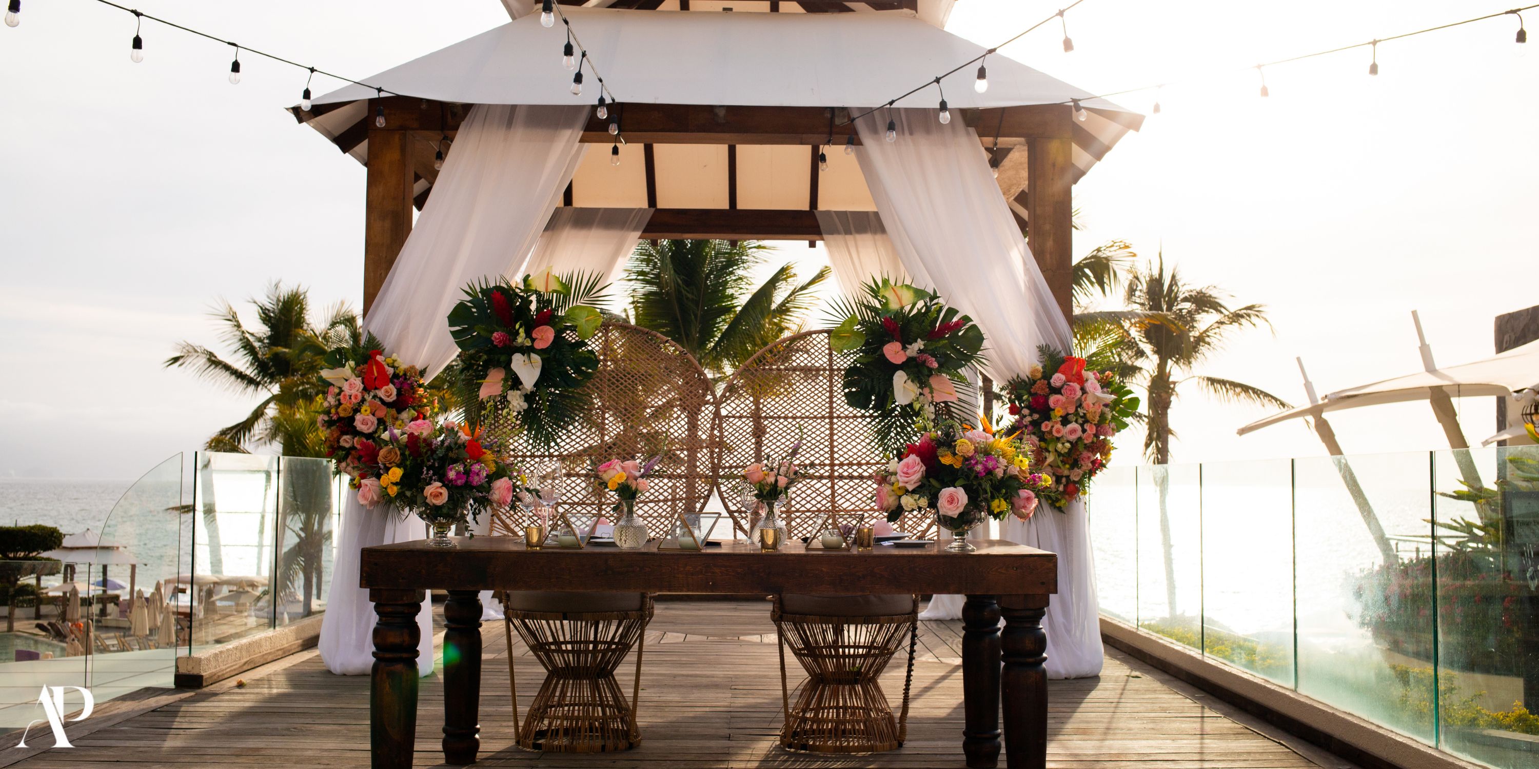 Destination wedding table setup at Dreams Vallarta Bay, florals under a canopy by the ocean.