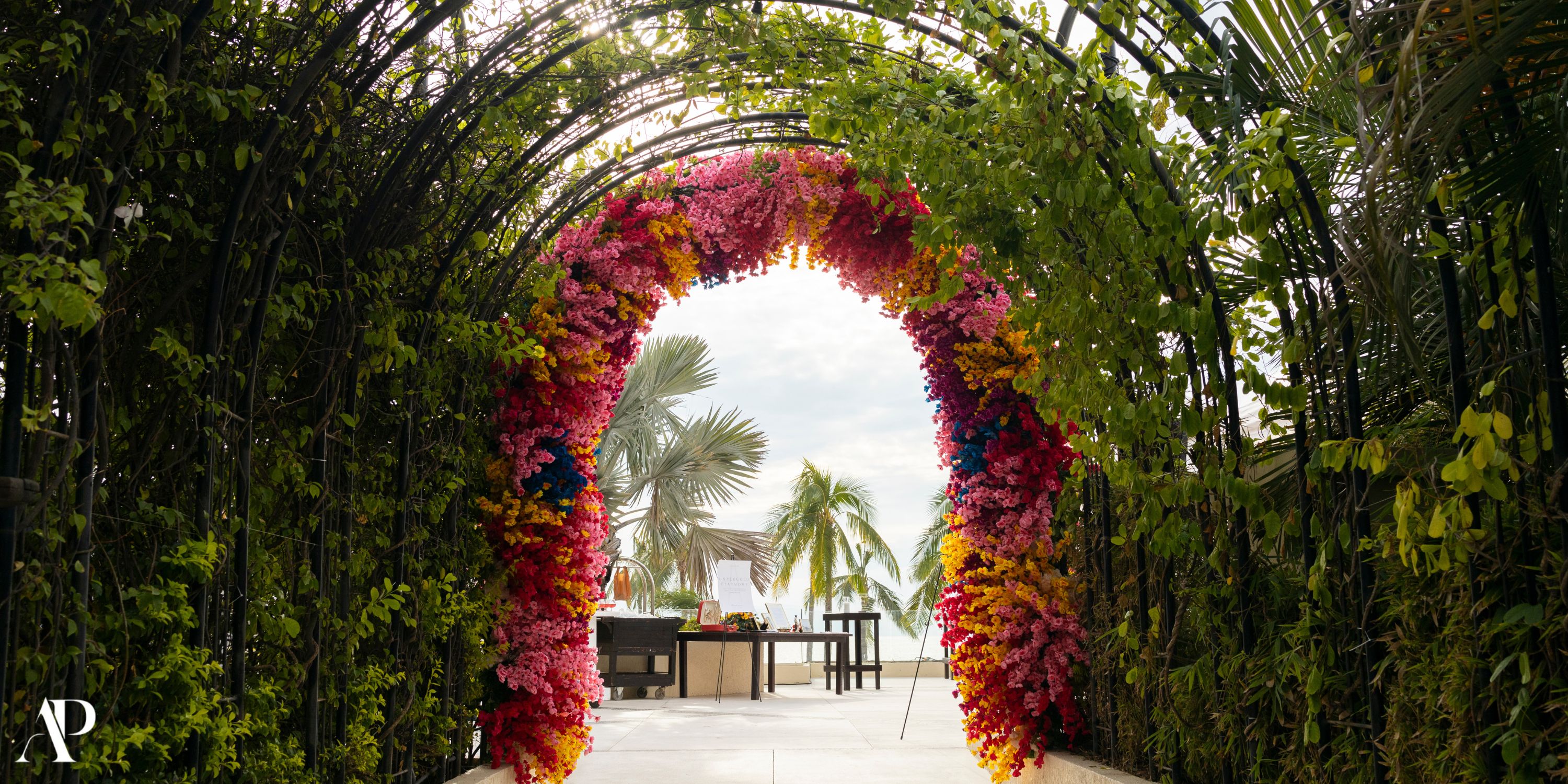 Dreams Vallarta Bay showcases a floral archway for a destination wedding on the outdoor patio.