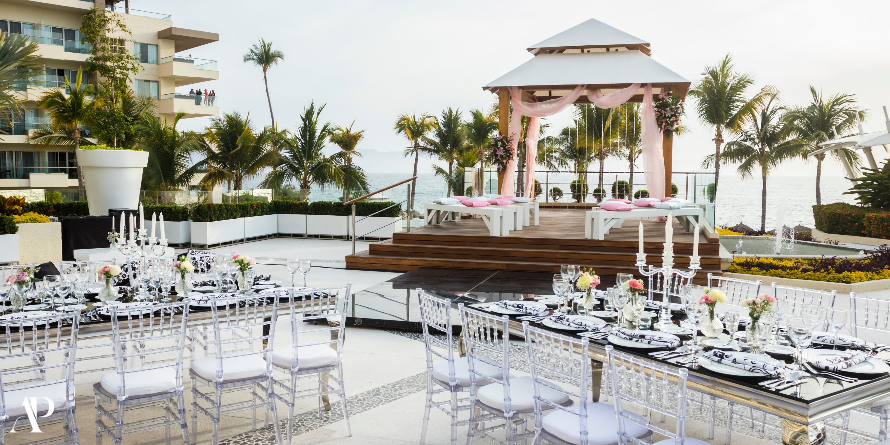 Destination wedding at Dreams Vallarta Bay with canopy, clear chairs, and oceanfront dining tables.