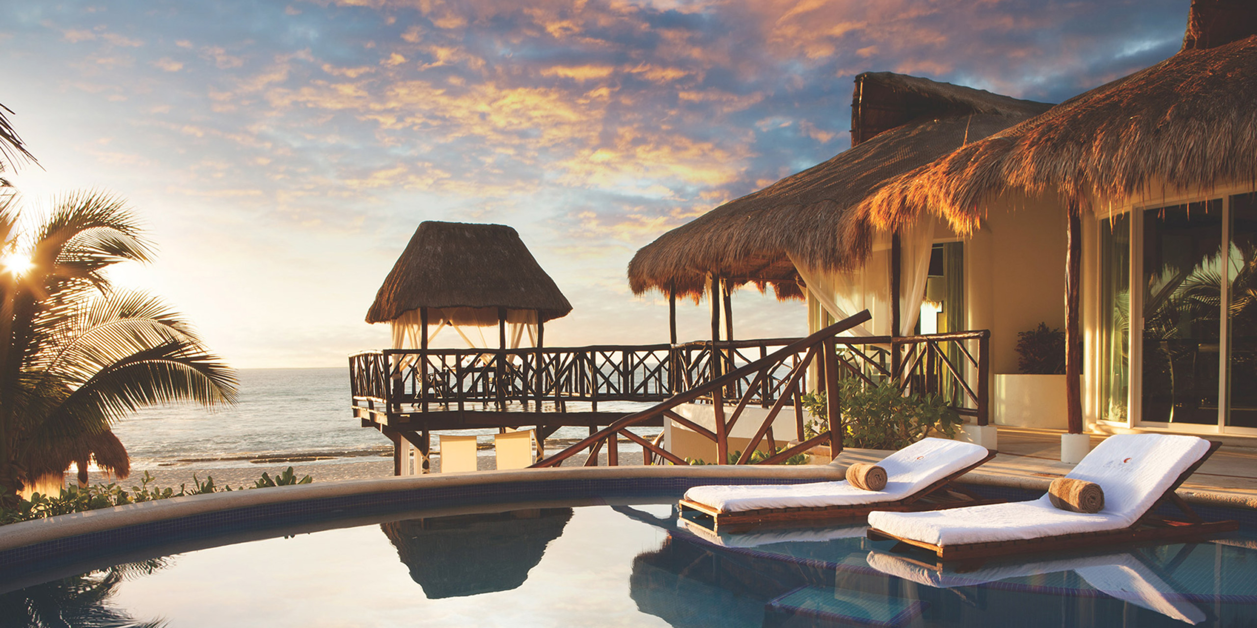 El Dorado Casitas Royale resort image with pool under a sunset sky
