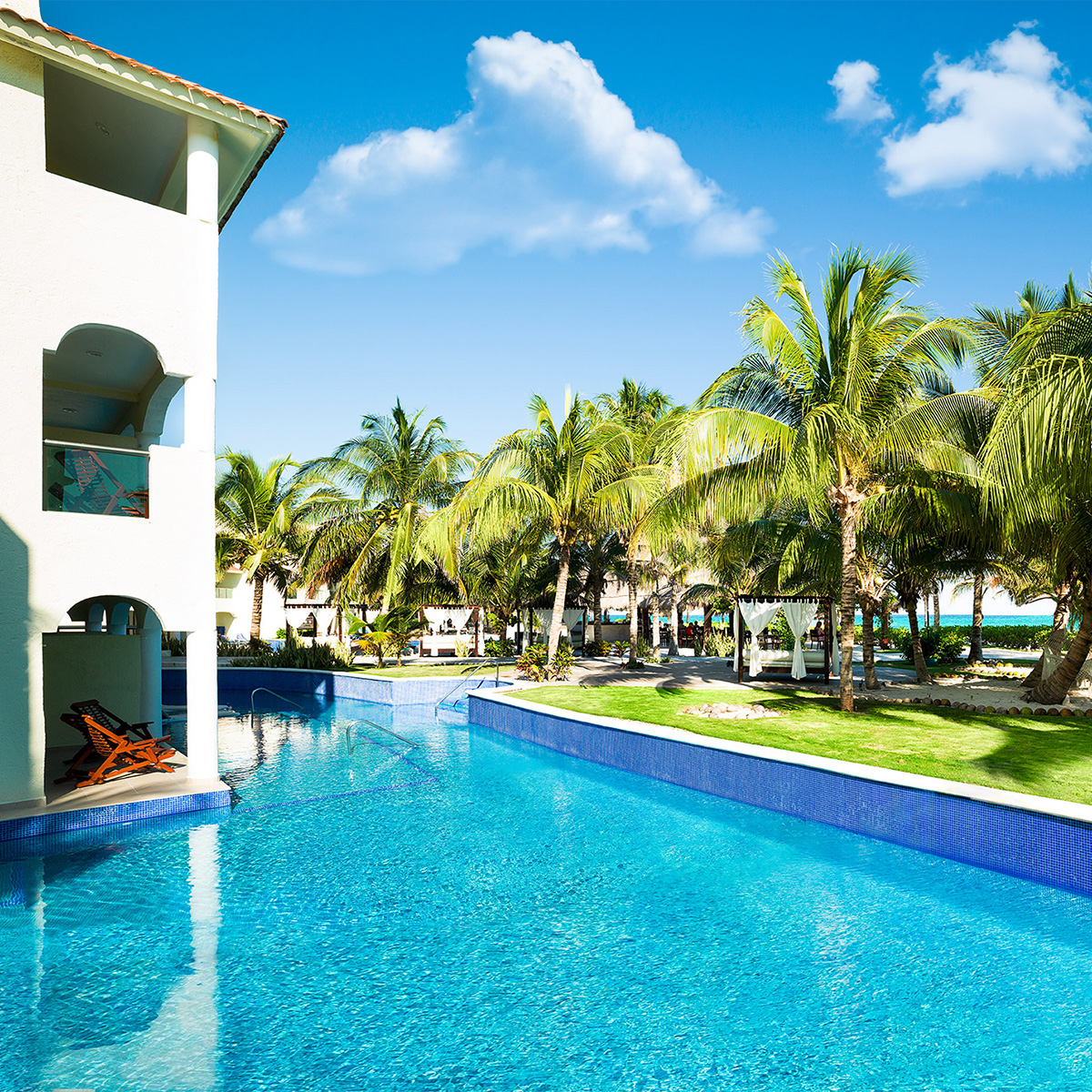 El Dorado Royale all inclusive resort pool with palm trees in the background under a clear Caribbean sky