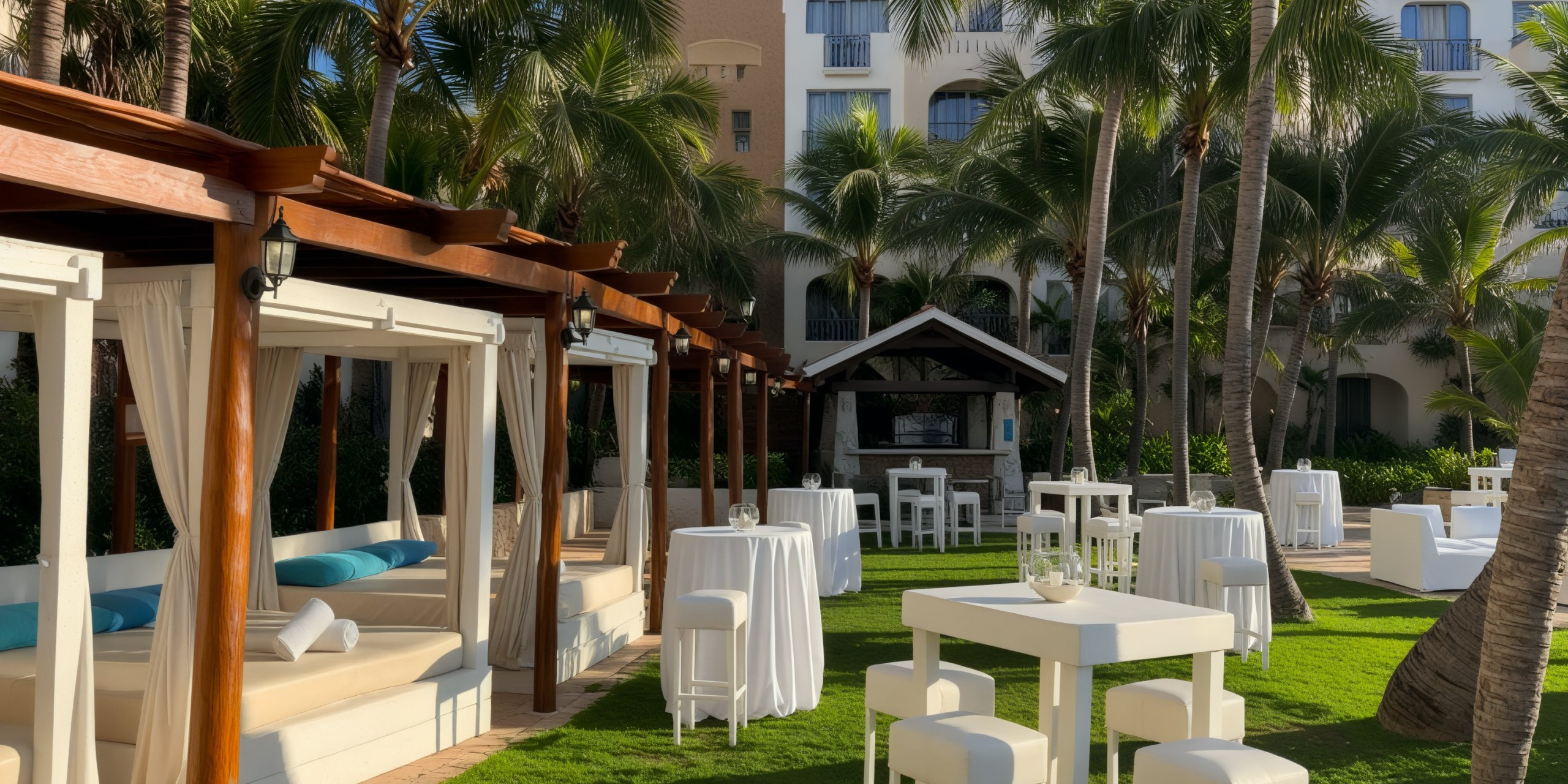 Fiesta Americana Condesa Cancun: A radiant outdoor resort perfect for a destination wedding, featuring cabanas, tables, and palm trees.