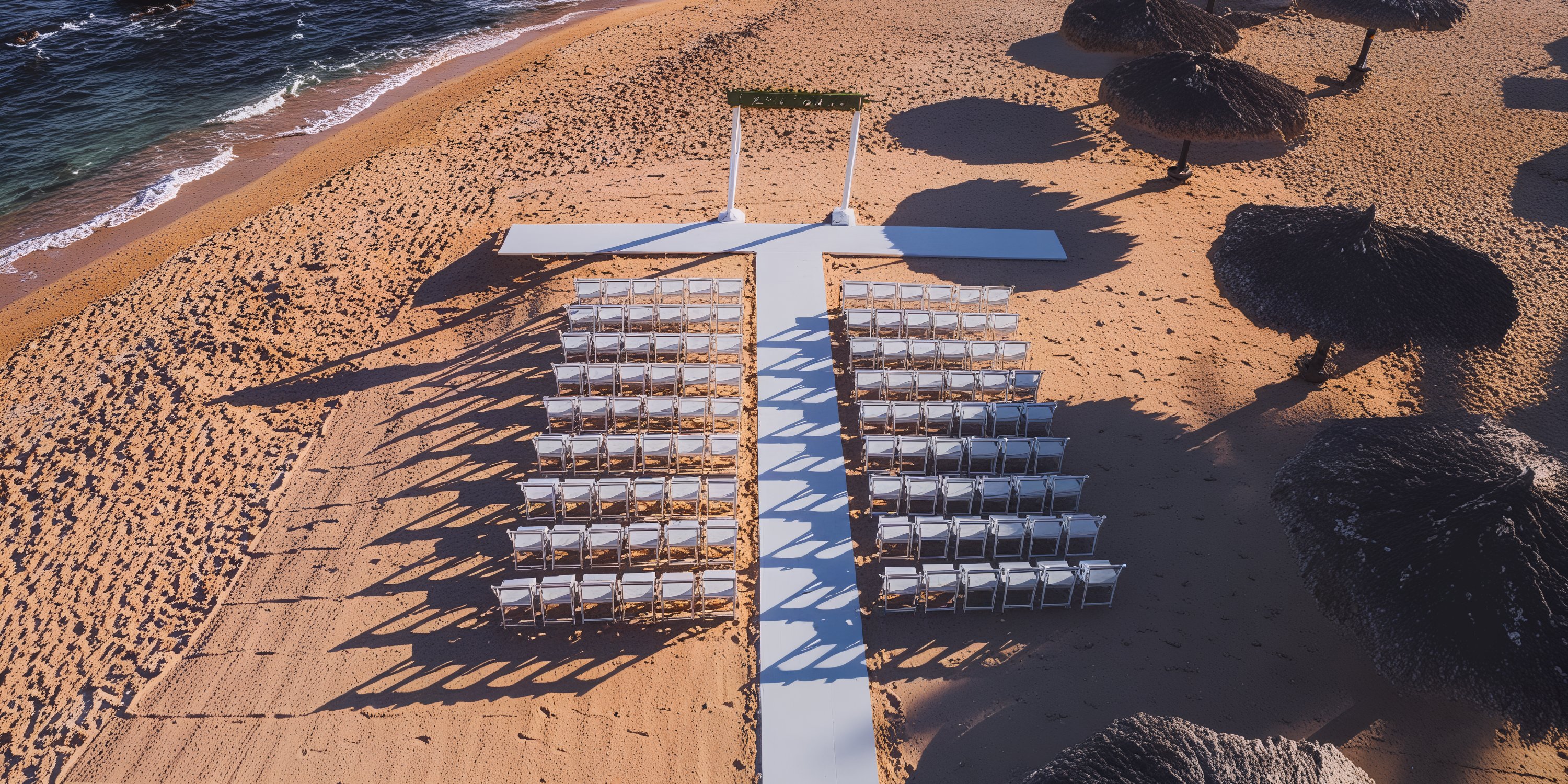 A destination wedding arrangement at Grand Fiesta Americana Los Cabos, featuring a sea-facing arch and elegantly arranged chairs on the beach.
