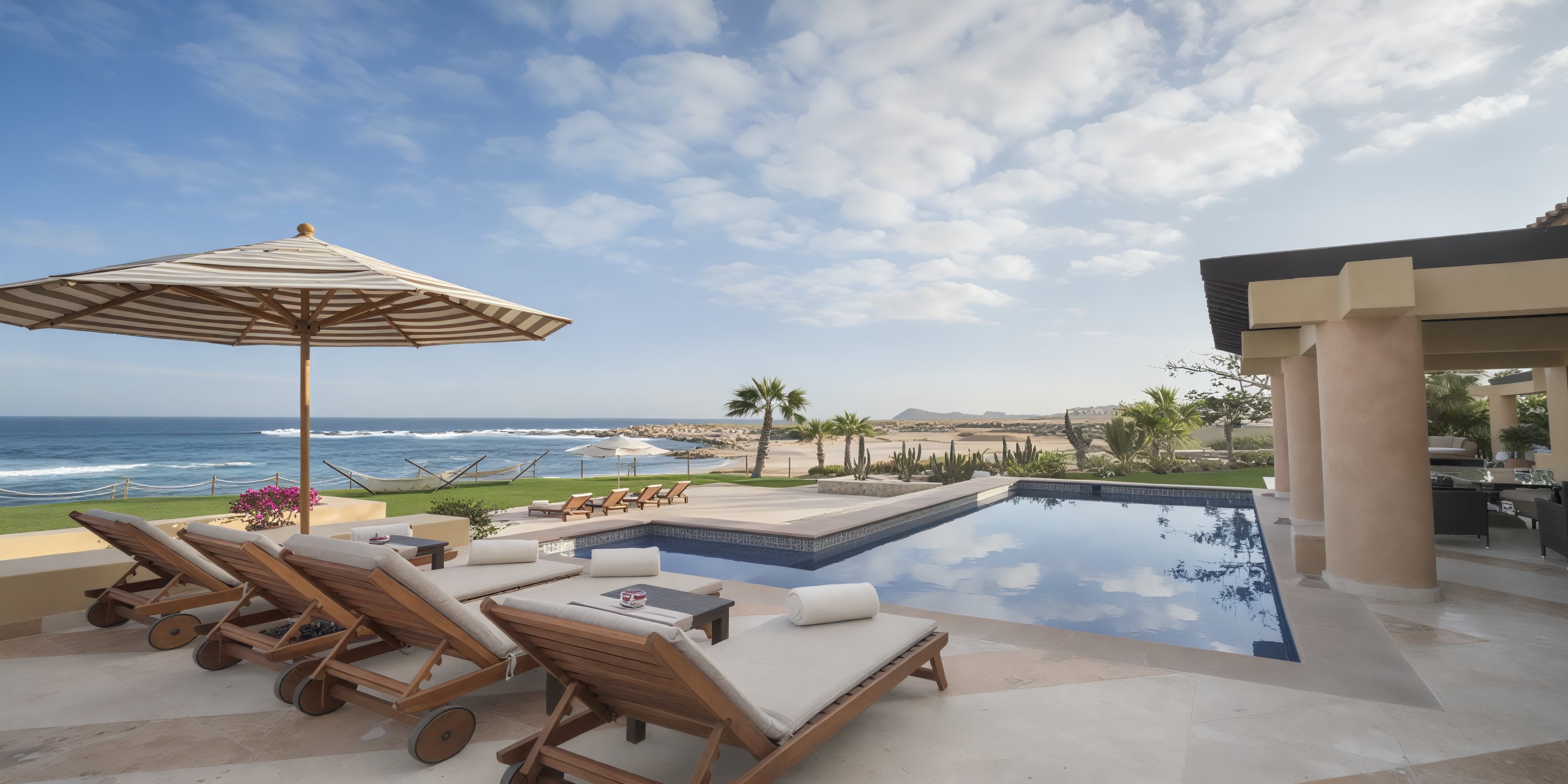Lounge chairs at the Grand Fiesta Americana Los Cabos offer idyllic ocean views, clear skies, and palm trees, creating the perfect setting for a unforgettable destination wedding.