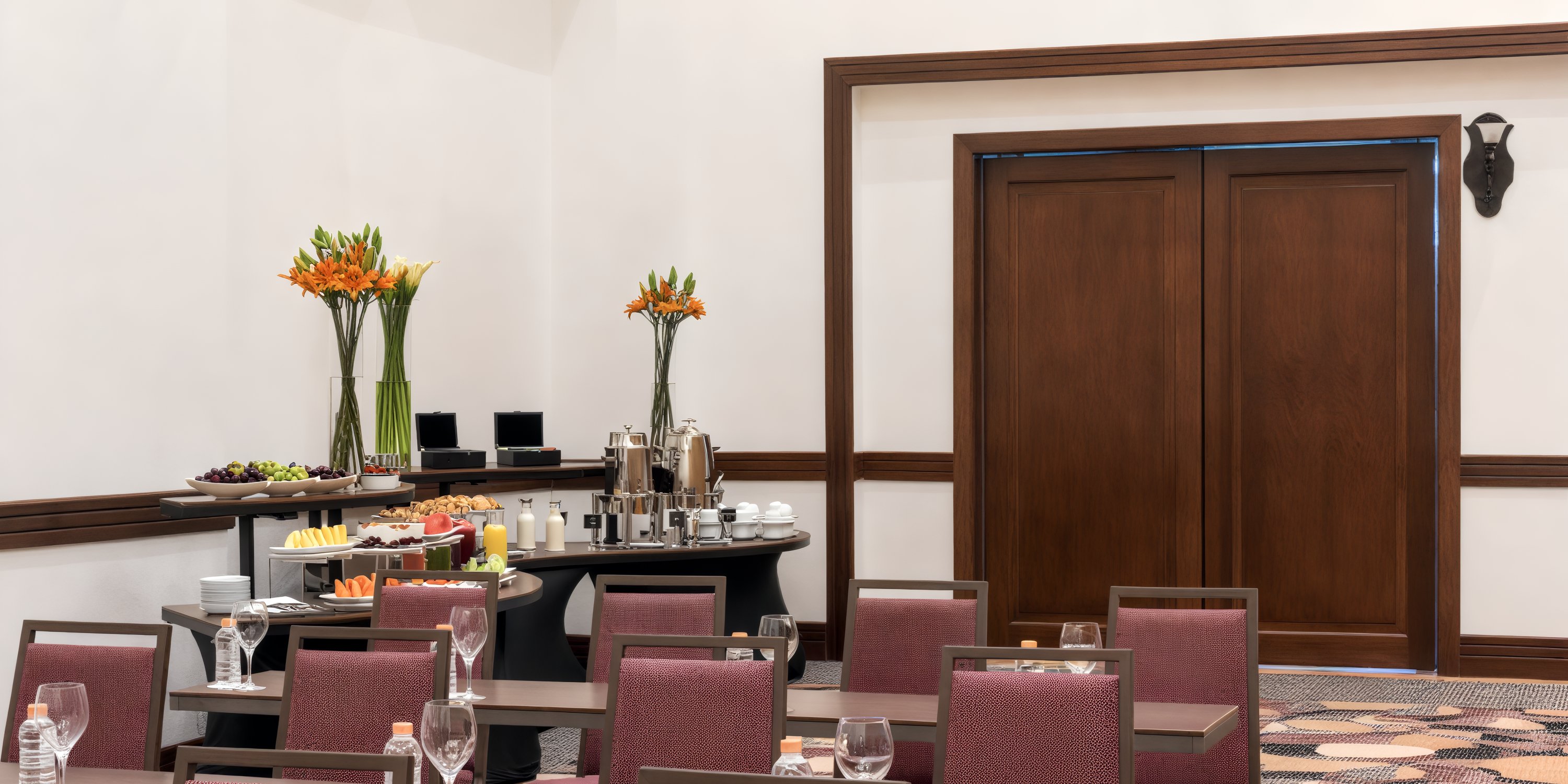 Hyatt Zilara Cancun presents a versatile conference room ideal for destination weddings, complete with tables, chairs, a buffet setup, and an array of food and drinks.