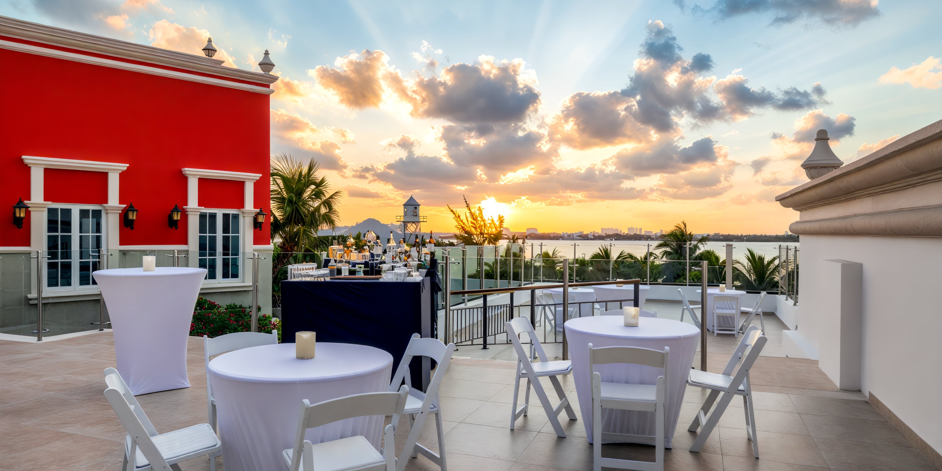 Experience the perfect destination wedding at Hyatt Zilara Cancun, where a stunning terrace awaits, complete with elegant tables and breathtaking sunset views over the shimmering water and distant cityscape.