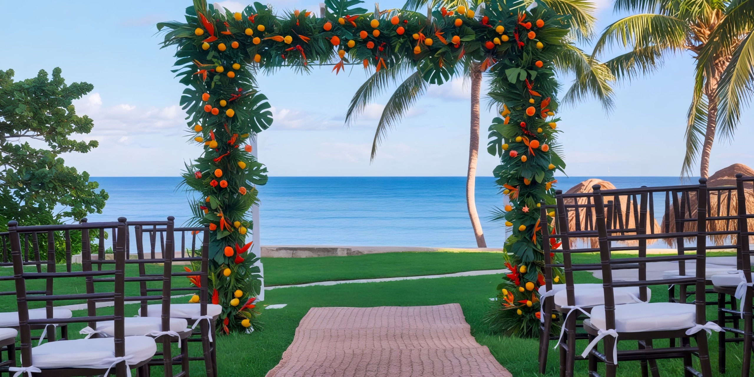 A stunning wedding arch adorned with vibrant flowers, set against the picturesque backdrop of a beach and ocean view at Hyatt Ziva Riviera Cancun, perfect for a destination wedding.