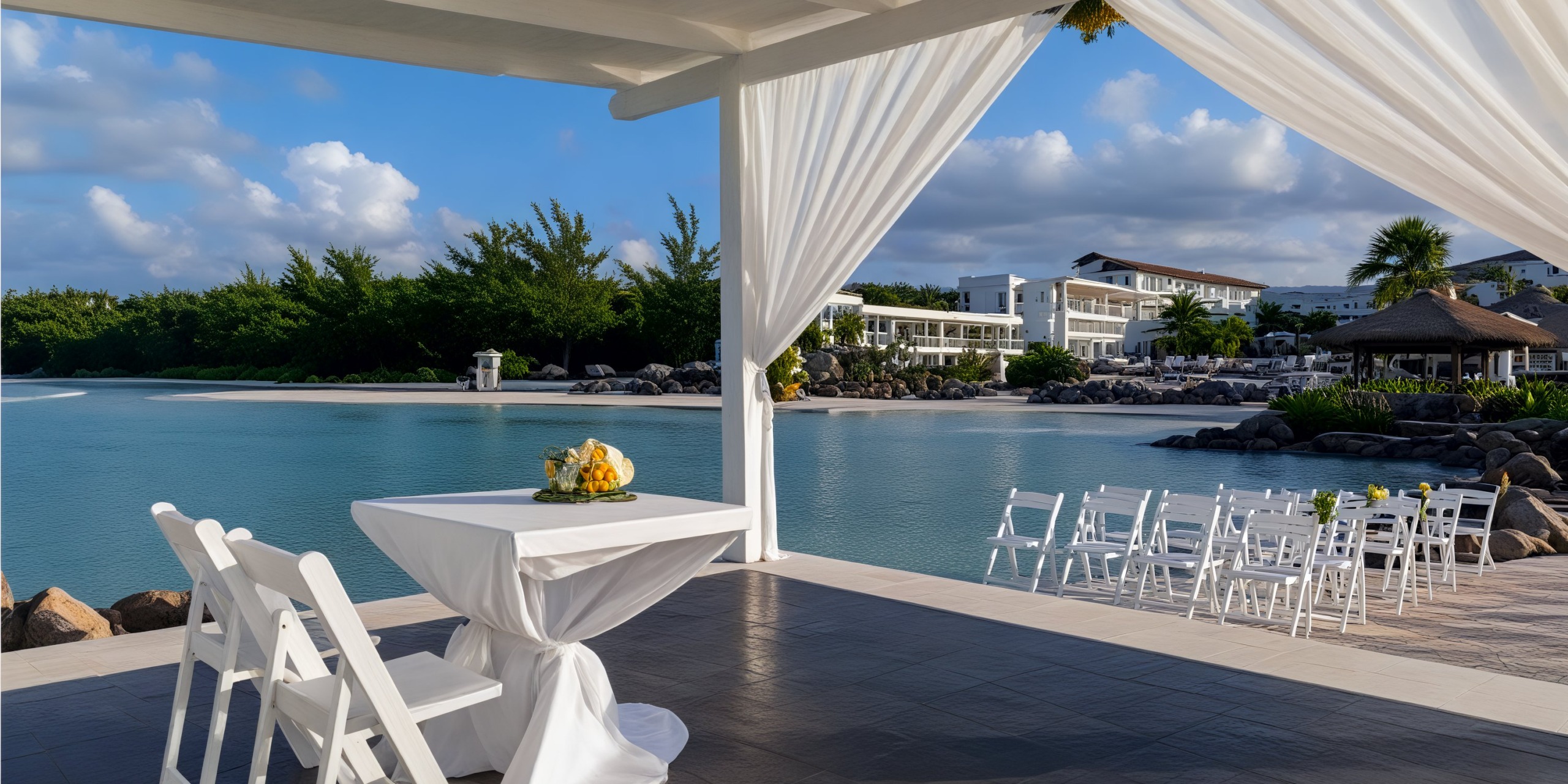 A picturesque beachfront destination wedding setup at Hideaway at Royalton Blue Waters, featuring elegantly arranged chairs and a beautifully adorned table.