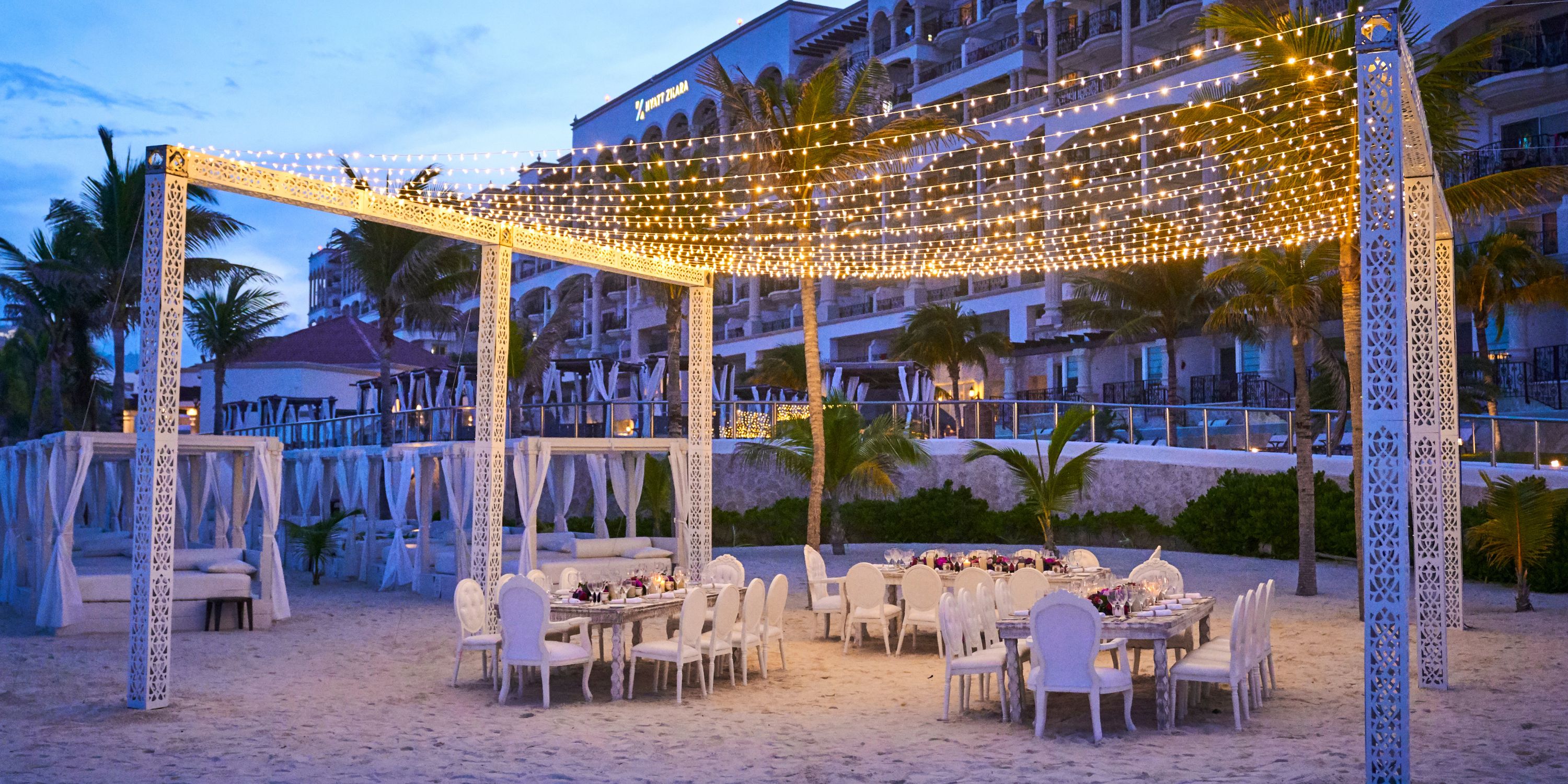 Beachside dining under string lights at dusk, perfect for a destination wedding at Hyatt Zilara Cancun.
