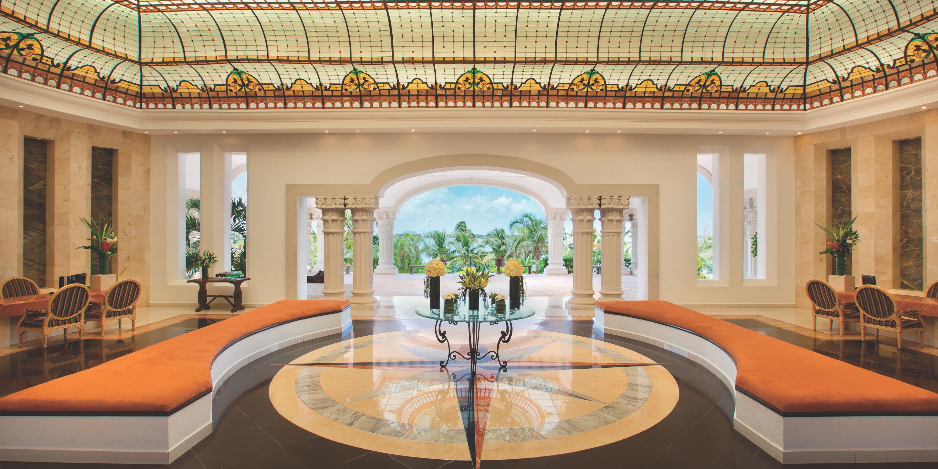 Hyatt Zilara Cancun’s spacious lobby, ideal for a destination wedding, has a stained glass ceiling and orange benches.