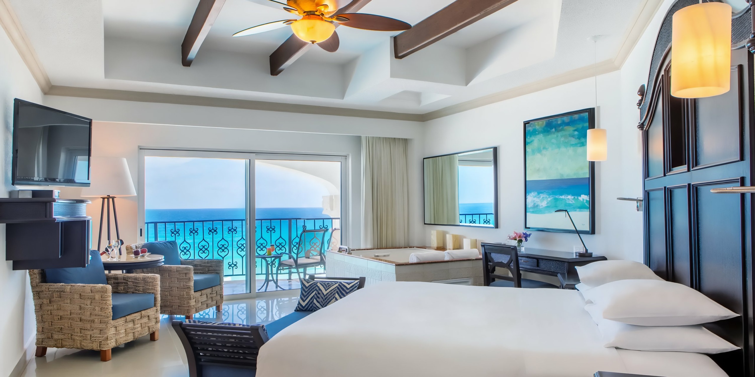 Hyatt Zilara Cancun hotel room with a large bed, ceiling fan, elegant furniture, and a balcony overlooking the ocean.