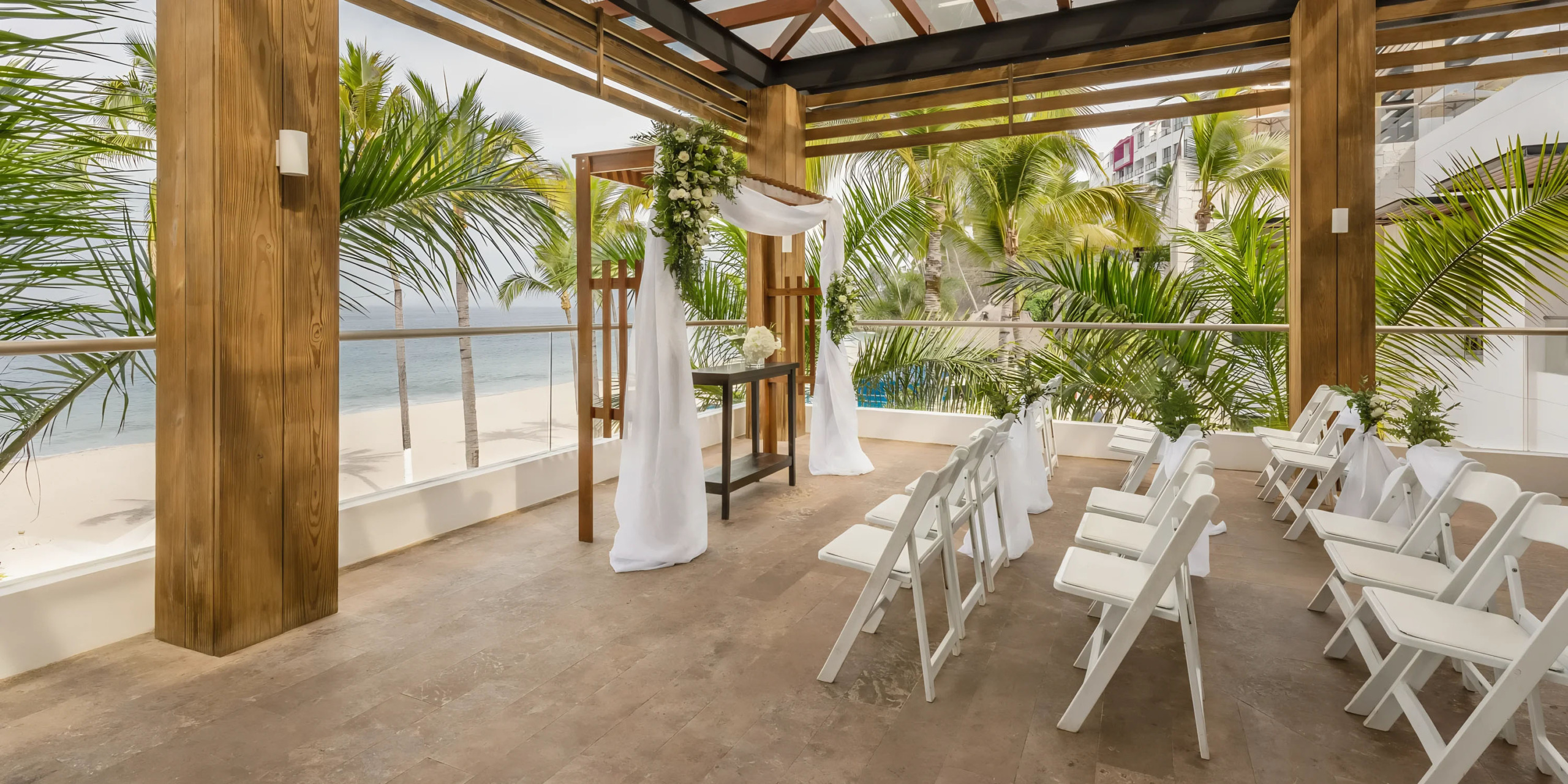 Hyatt Ziva Puerto Vallarta beachfront wedding venue set up with white chairs and an altar, ready for a ceremony.