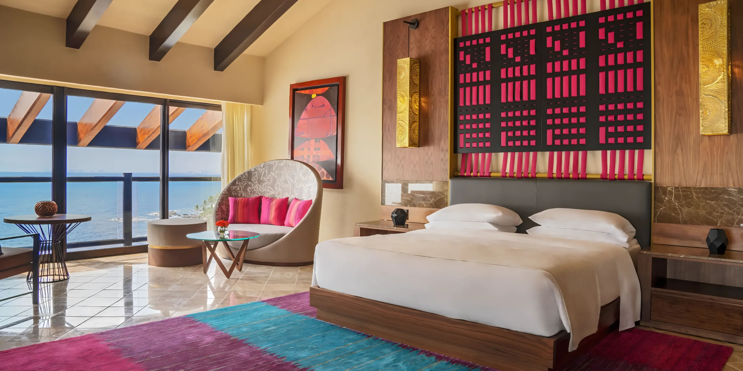 Hyatt Ziva Puerto Vallarta room with a waterfront view, vibrant decor, and circular lounge chair.