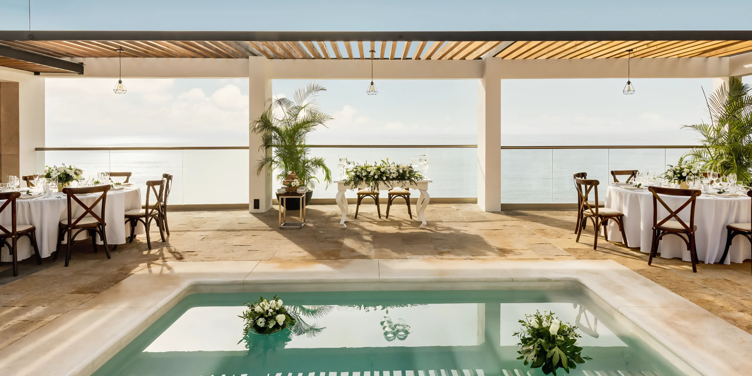 Elegant outdoor dining area with a pool overlooking the sea at Hyatt Ziva Puerto Vallarta.