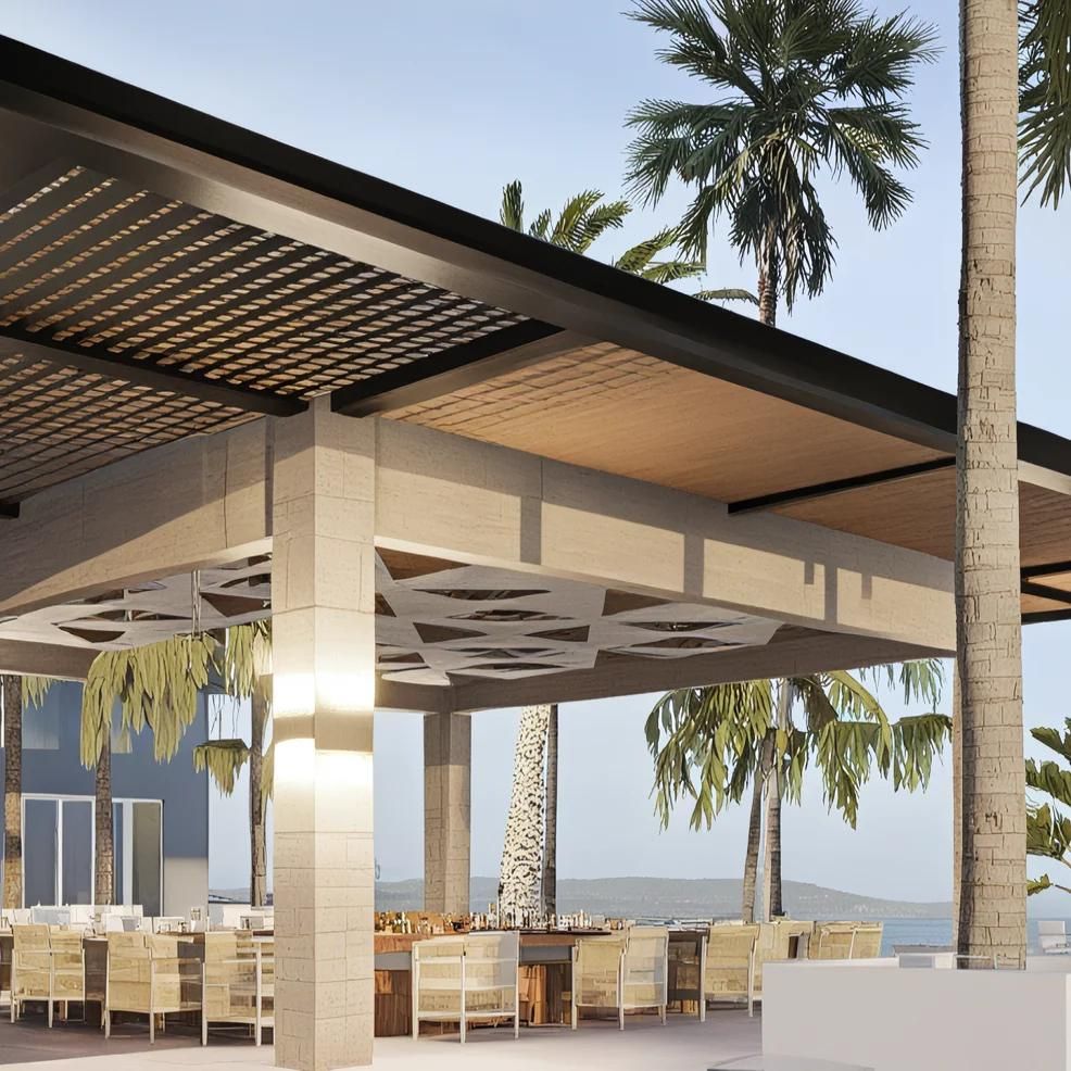 Outdoor dining area with modern architecture featuring a wooden pergola, white tables and chairs. Palm trees and a clear sky are visible in the background.