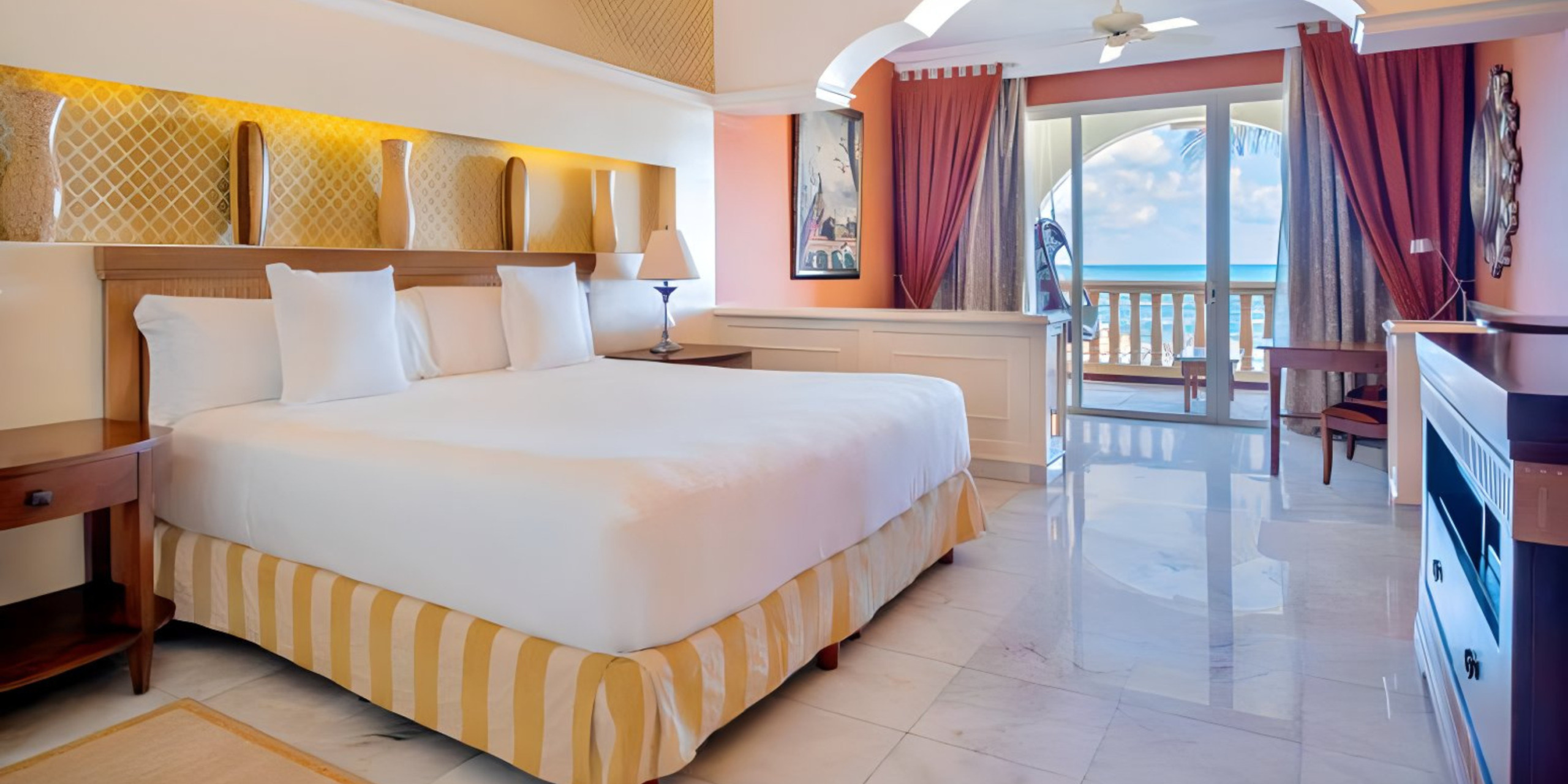 A Iberostar Grand Paraiso room with a balcony overlooking the ocean, perfect for a destination wedding.