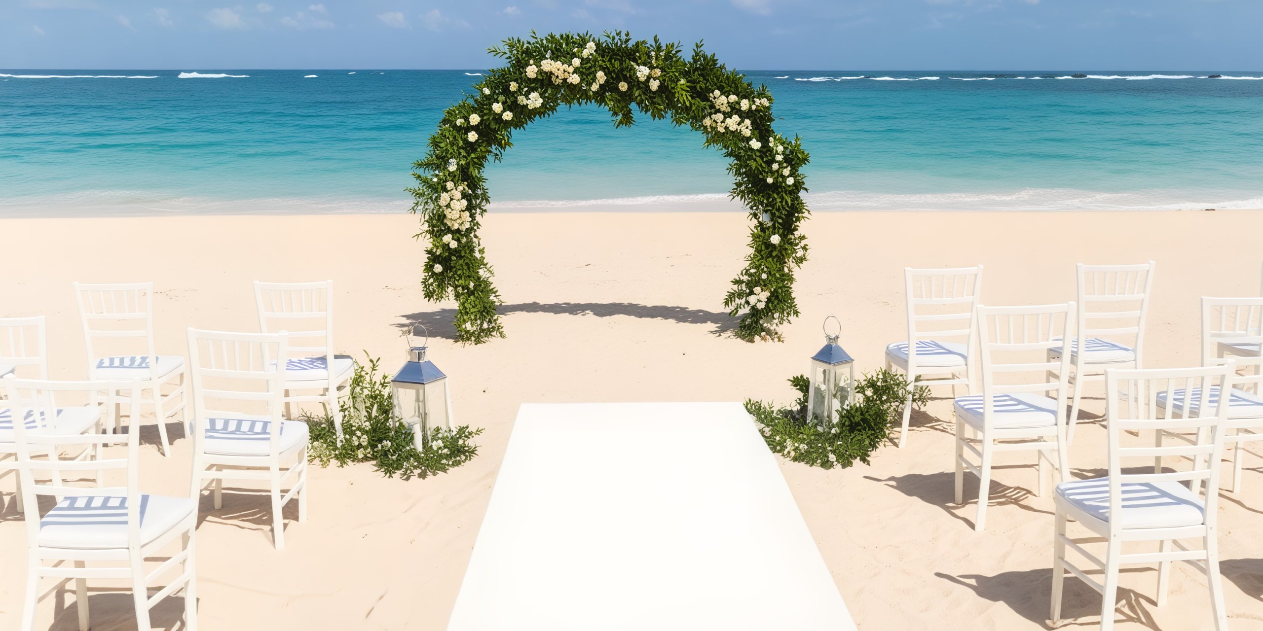 Iberostar Selection Bavaro offers a stunning destination wedding setting, featuring a floral arch, elegant white chairs, and lanterns by the ocean.