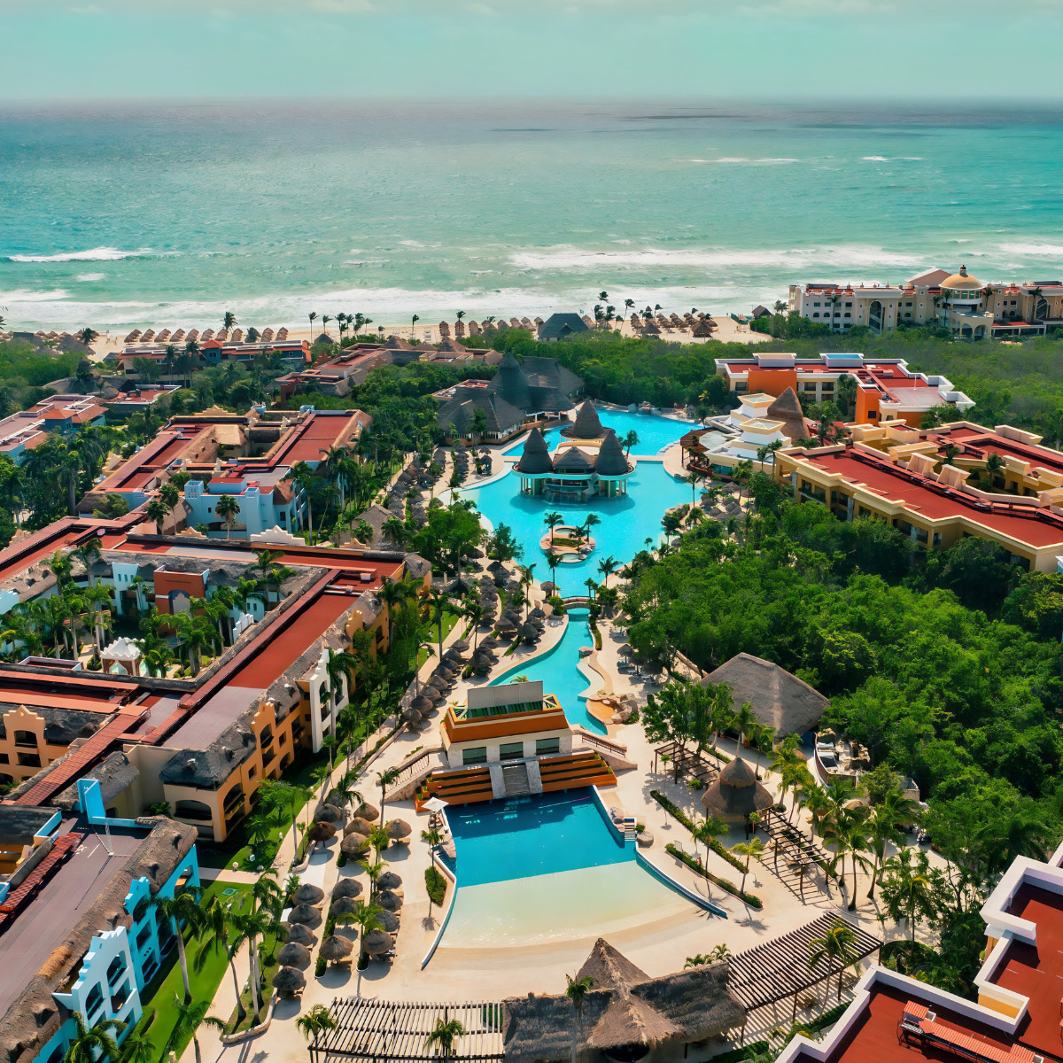 An aerial view of Iberostar Selection Paraíso Maya Suites and the ocean prepared for a wedding.