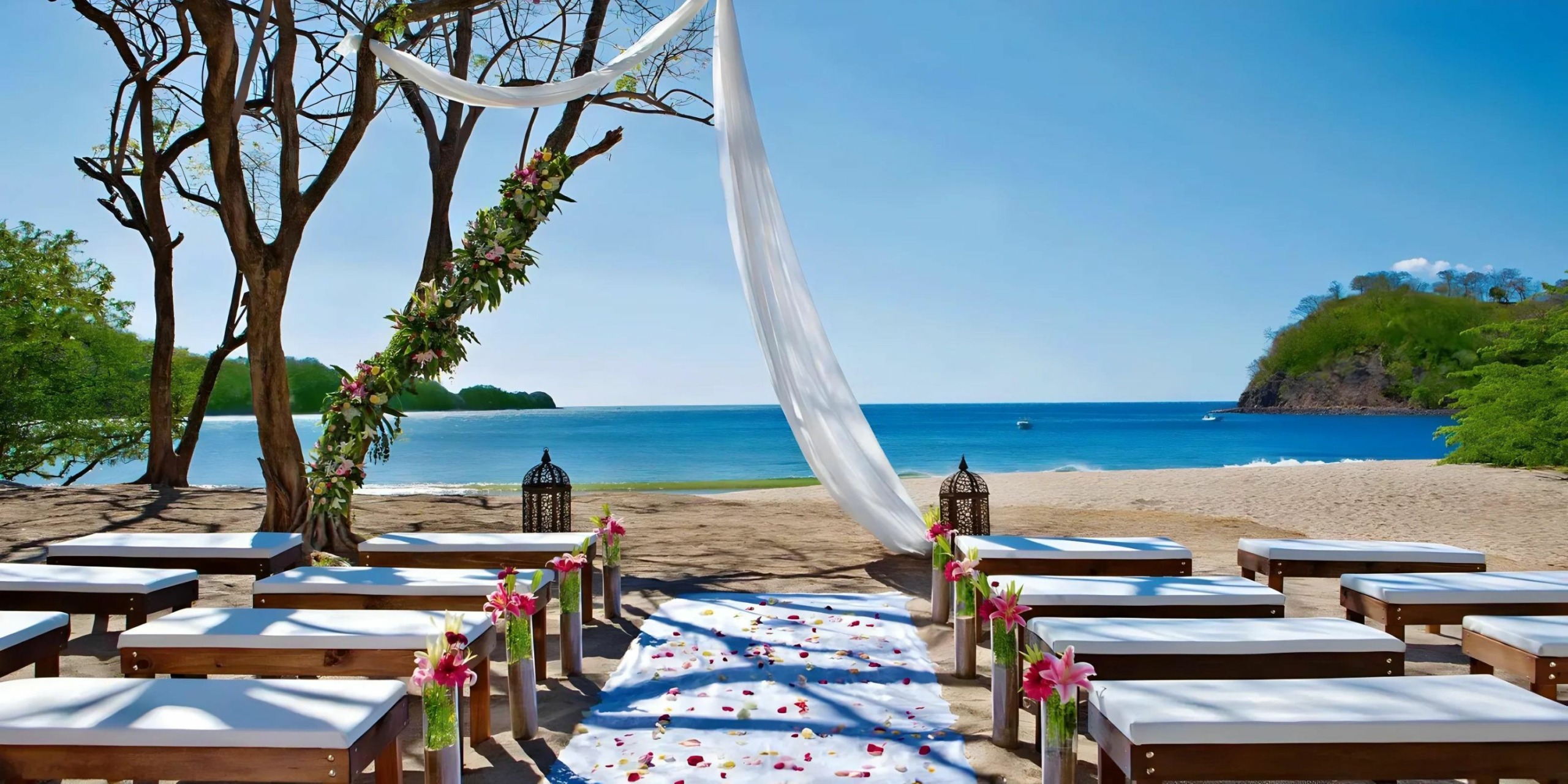 A Dreams Las Mareas wedding ceremony set up on the beach with chairs and flowers.