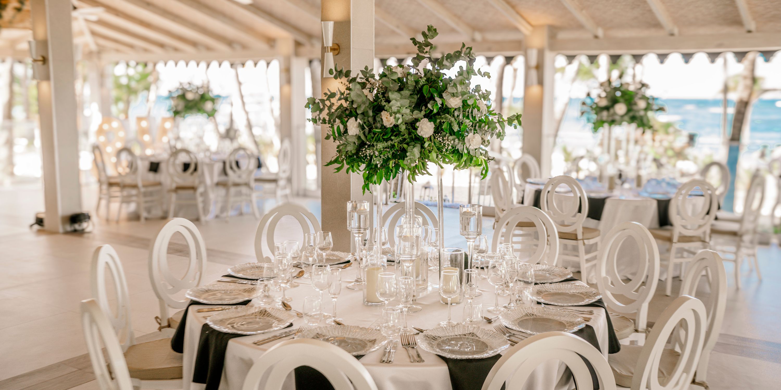 Elegant wedding table with floral centerpieces at Hotel Riu Palace Macao in a spacious, airy venue.
