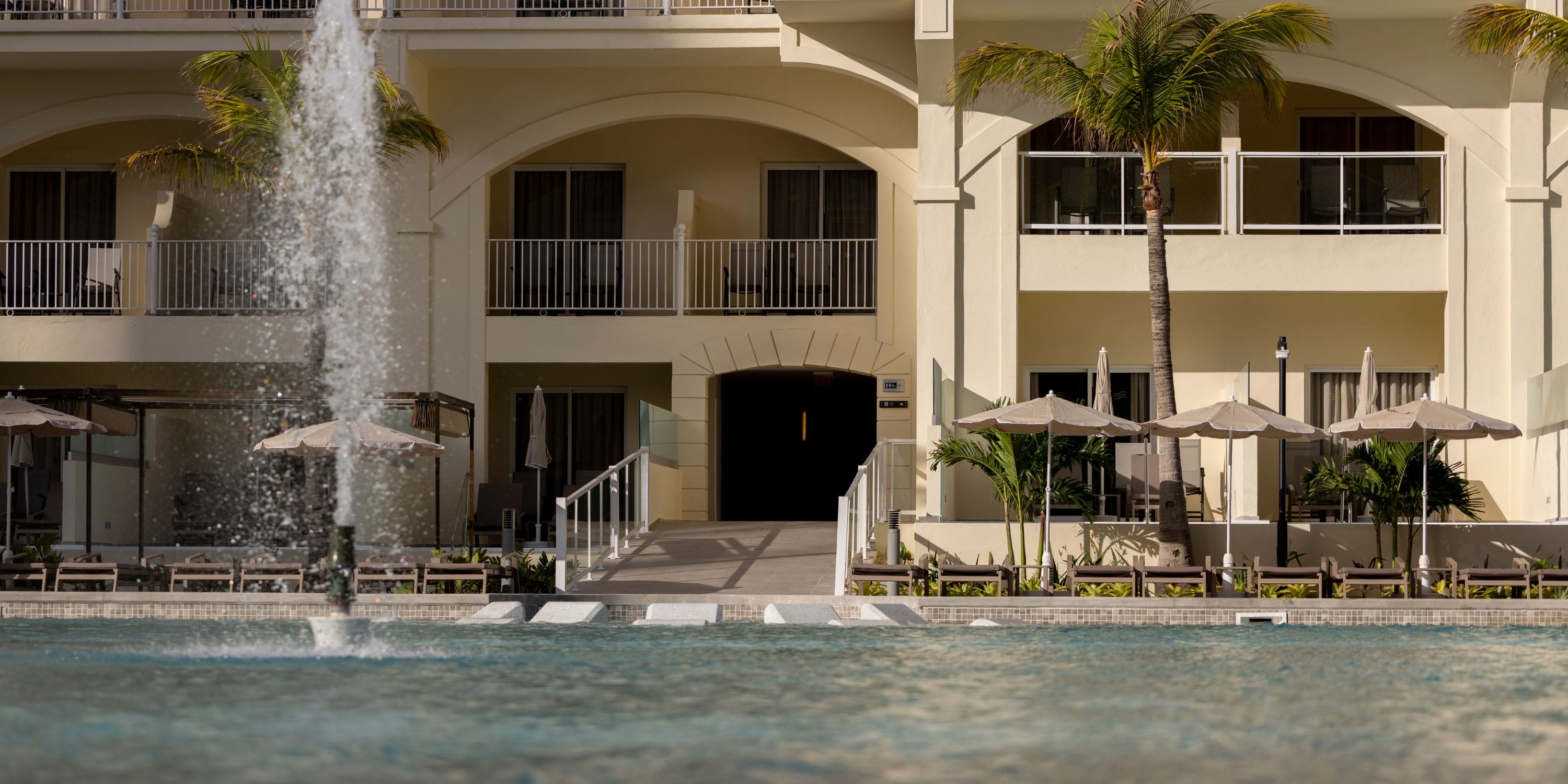 Fountain at Hotel Riu Palace Aruba, a popular destination wedding spot with balconies and umbrellas.