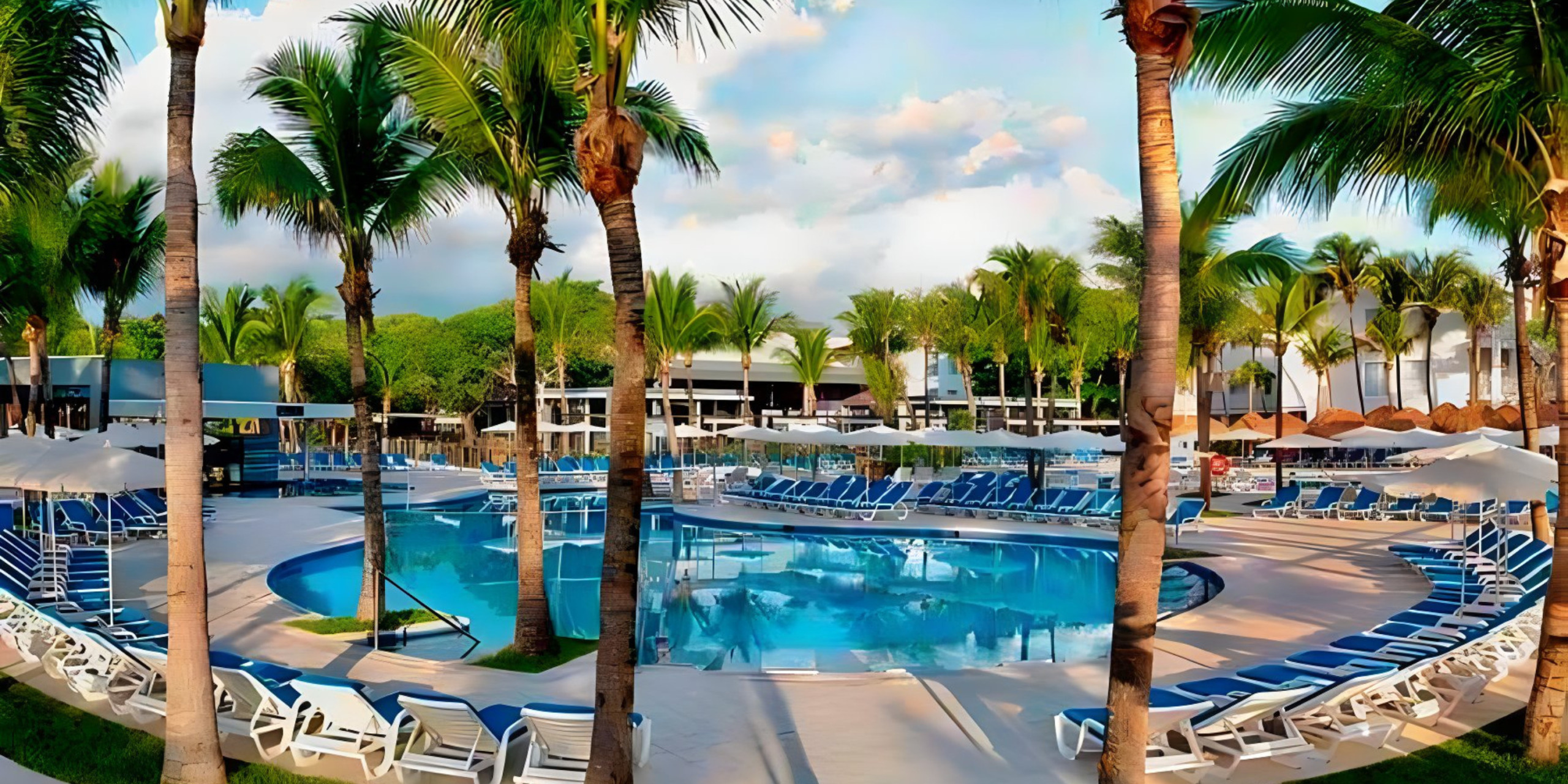A Hotel Riu Yucatan with a swimming pool, lounge chairs, and palm trees.