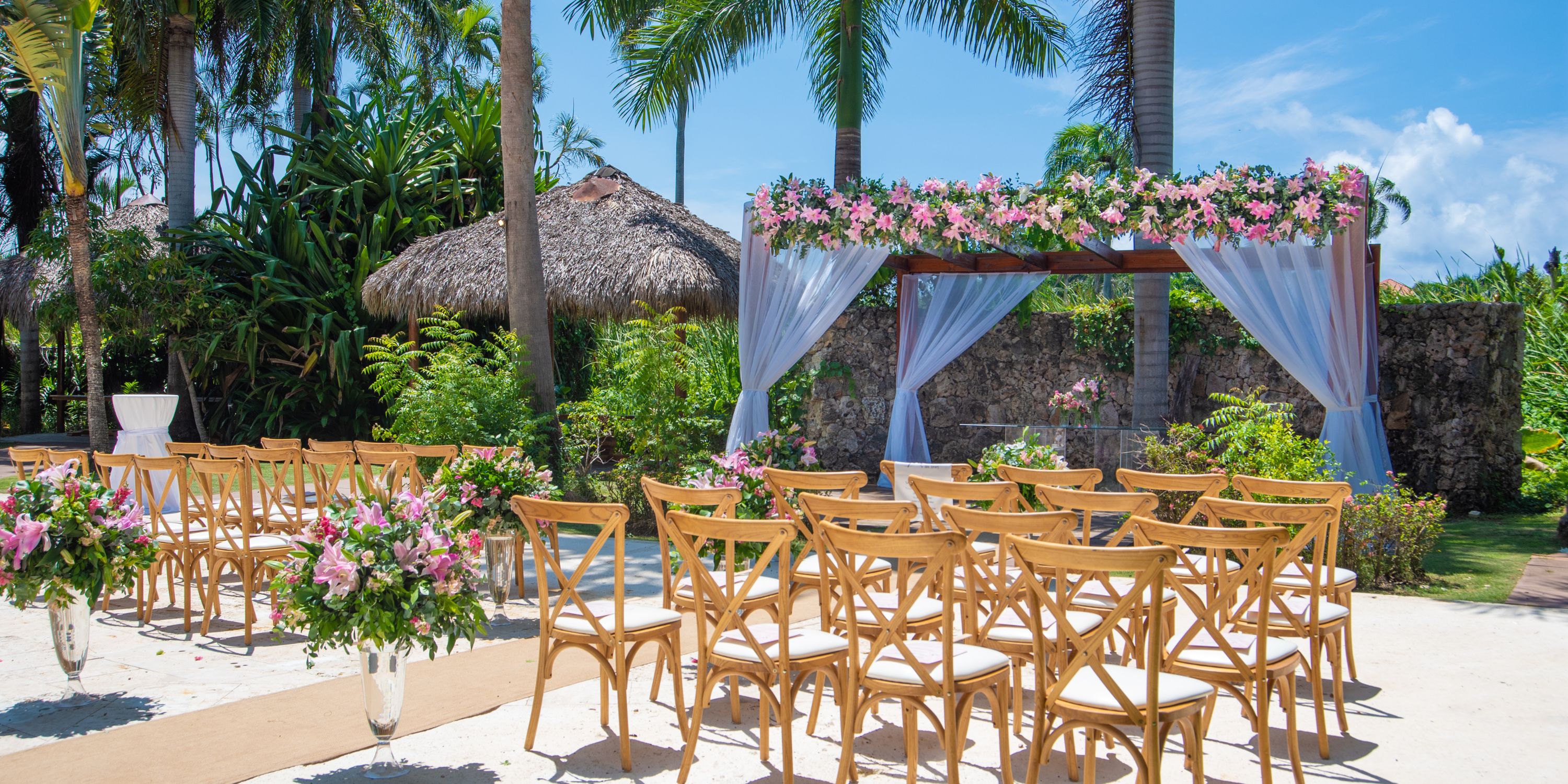 Destination wedding at Royalton Punta Cana with wooden chairs, floral arrangements, and a decorated arch.