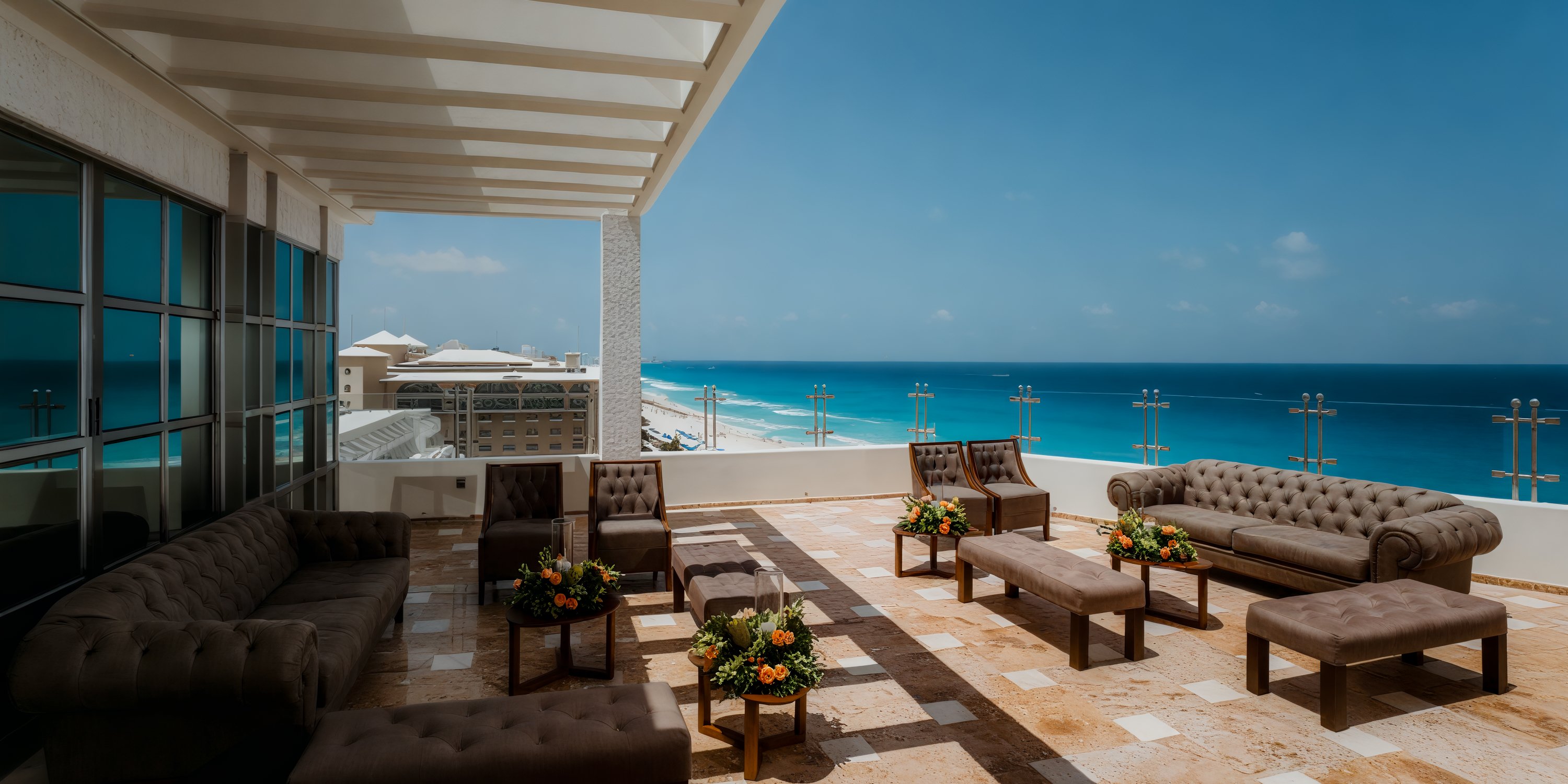 Sandos Cancun Lifestyle Resort: Experience a breathtaking destination wedding with a rooftop lounge complete with comfortable sofas and stunning ocean views under a clear blue sky.