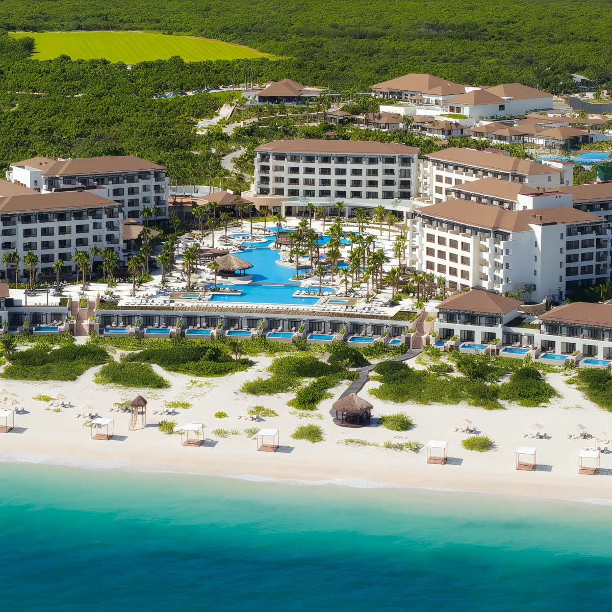Aerial view of Secrets Playa Mujeres, a beachfront resort featuring multiple buildings, a central pool area, and lush greenery. The foreground showcases a white sandy beach and turquoise ocean.