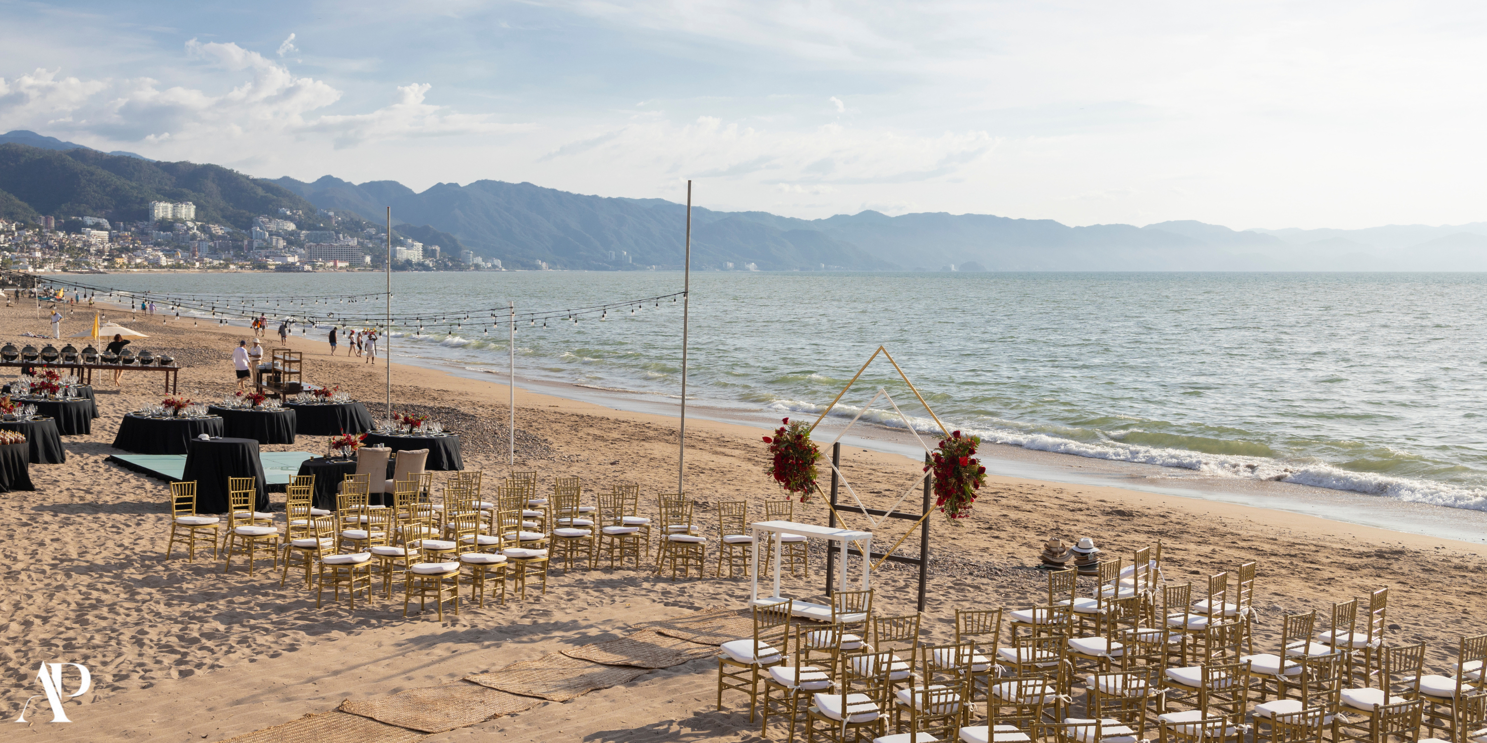 Beachfront destination wedding setup at Secrets Vallarta Bay with chairs, tables, and floral decor on sand.