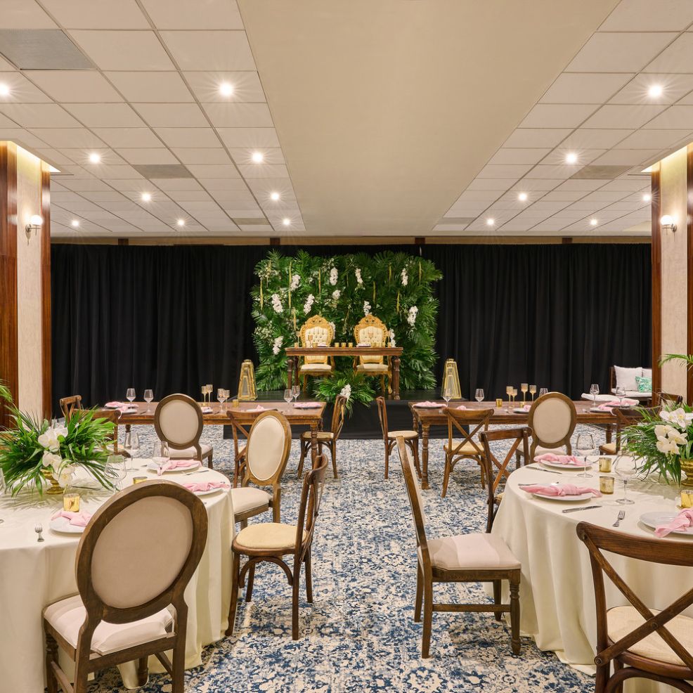 The Elegant Wyndham Alltra Vallarta hall, adorned with beautifully decorated tables and a stunning floral backdrop, is the perfect venue for a destination wedding or any special event.