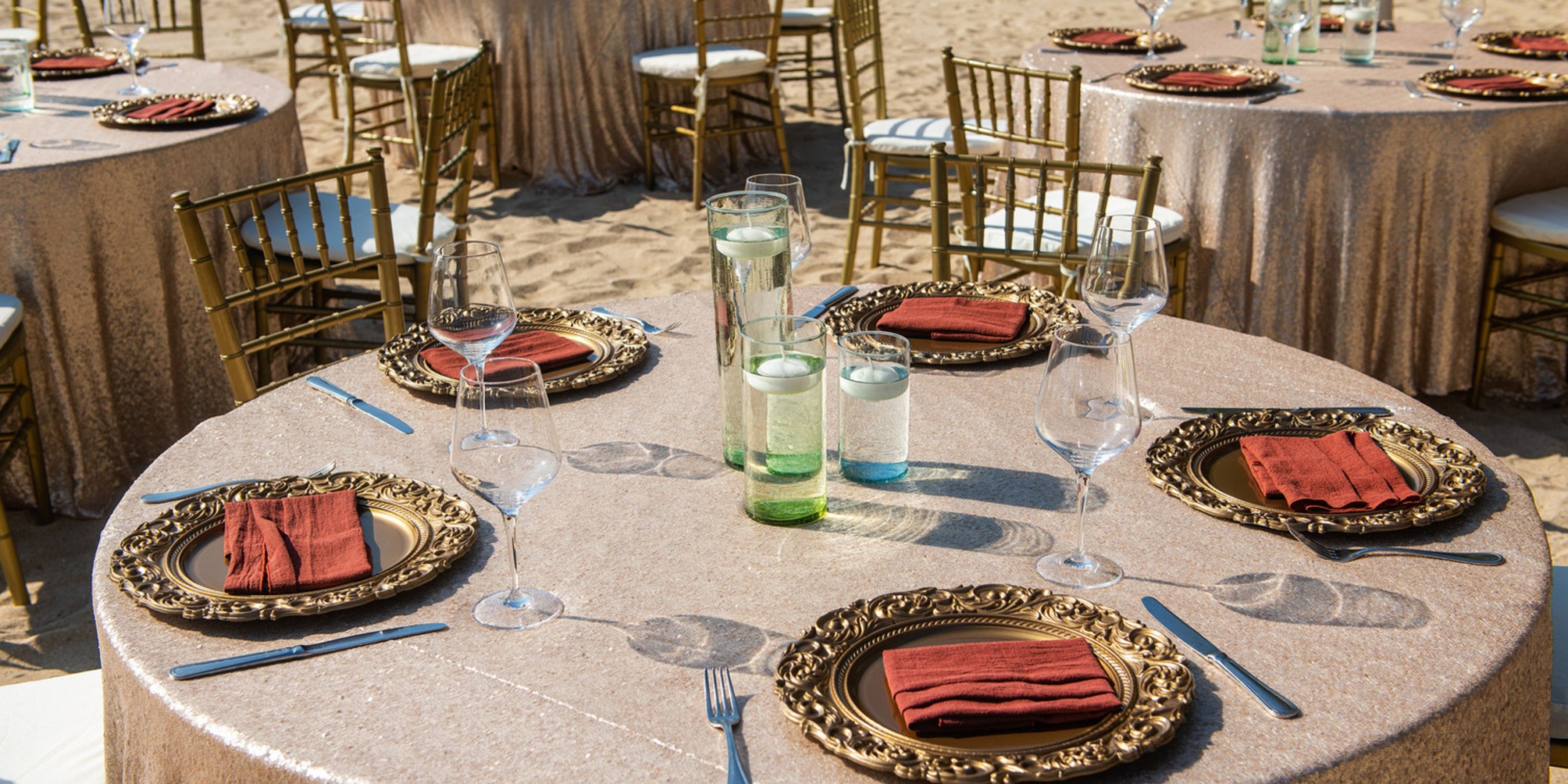 The elegant Wyndham Alltra Vallarta is beautifully arranged for a destination wedding, featuring gold accents and complemented by brown napkins.