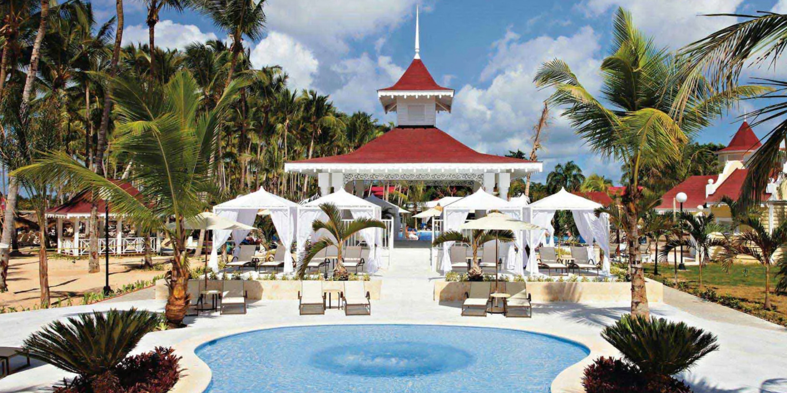 The Bahia Principe Luxury Bouganville area at a resort, with palm trees and a wedding gazebo.