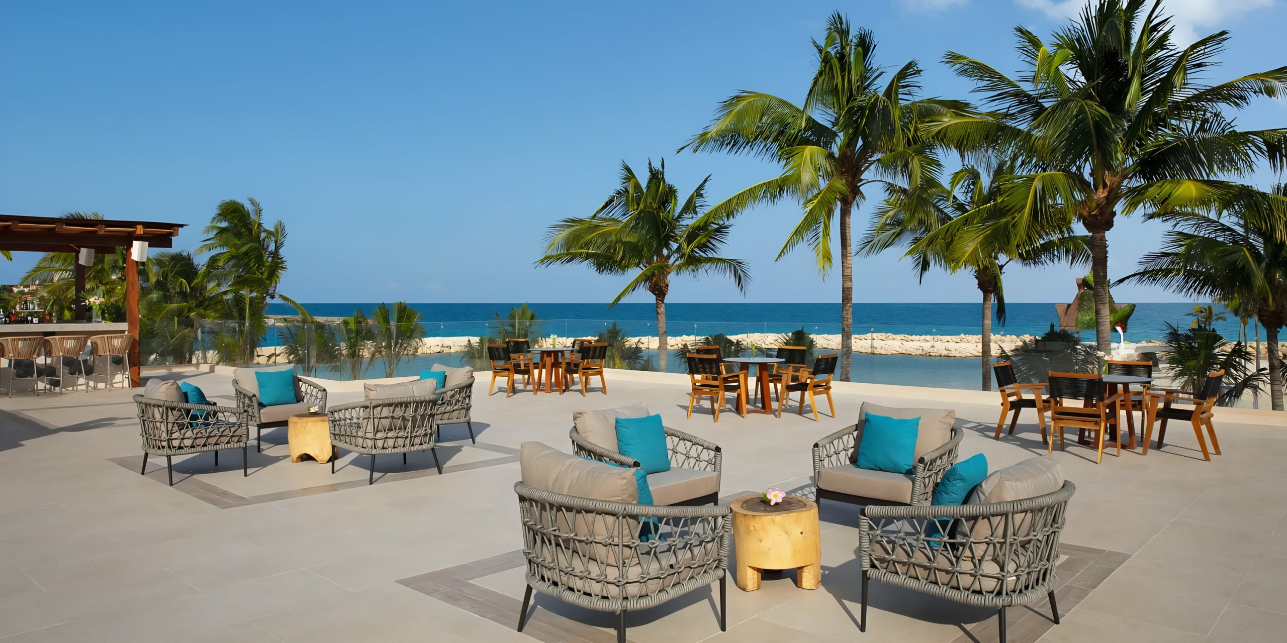 Dreams Aventuras Riviera Maya beachfront patio with seating area and ocean view.