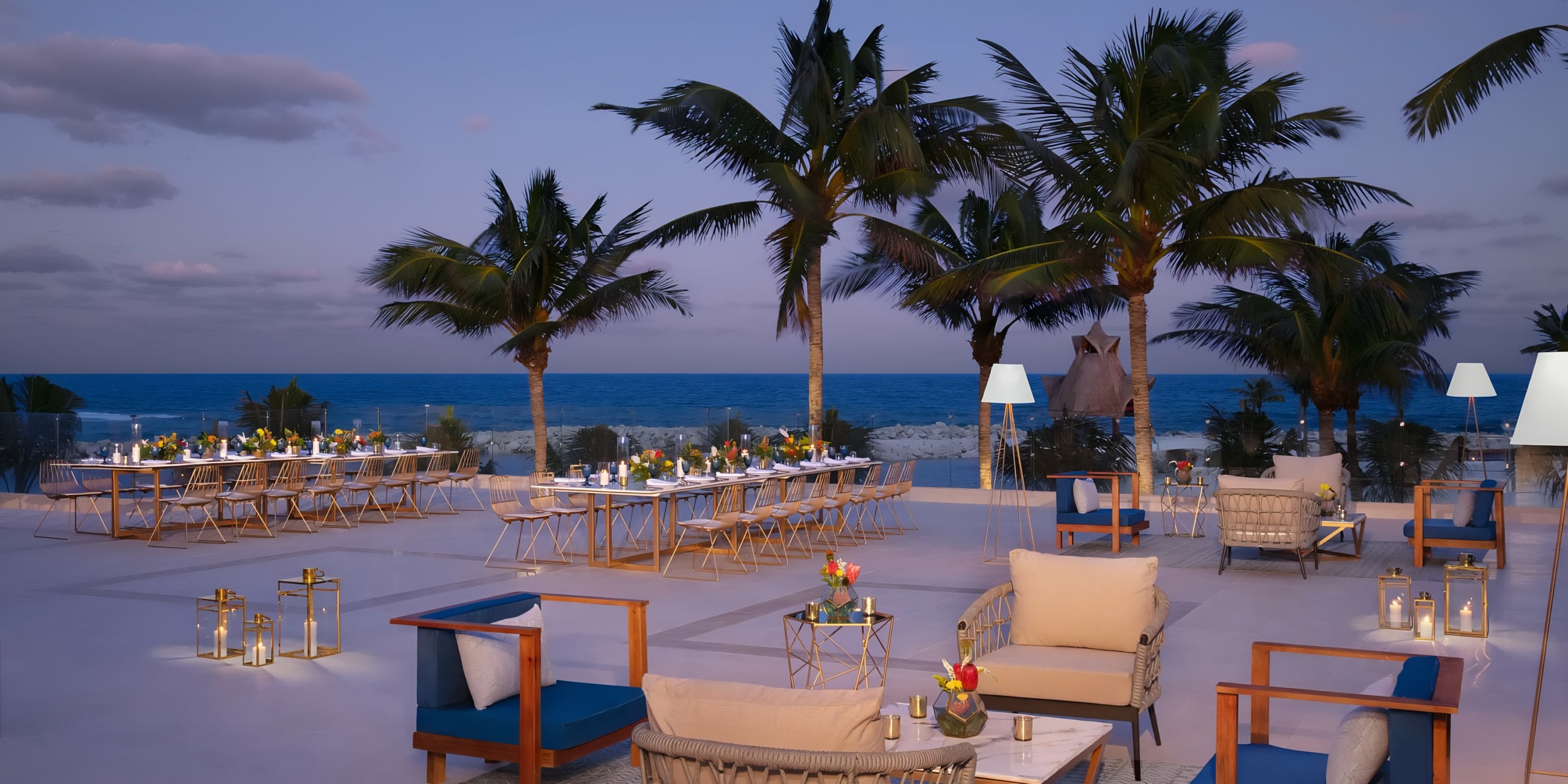 Dreams Aventuras Riviera Maya evening dining setup with palm trees and a serene sky.