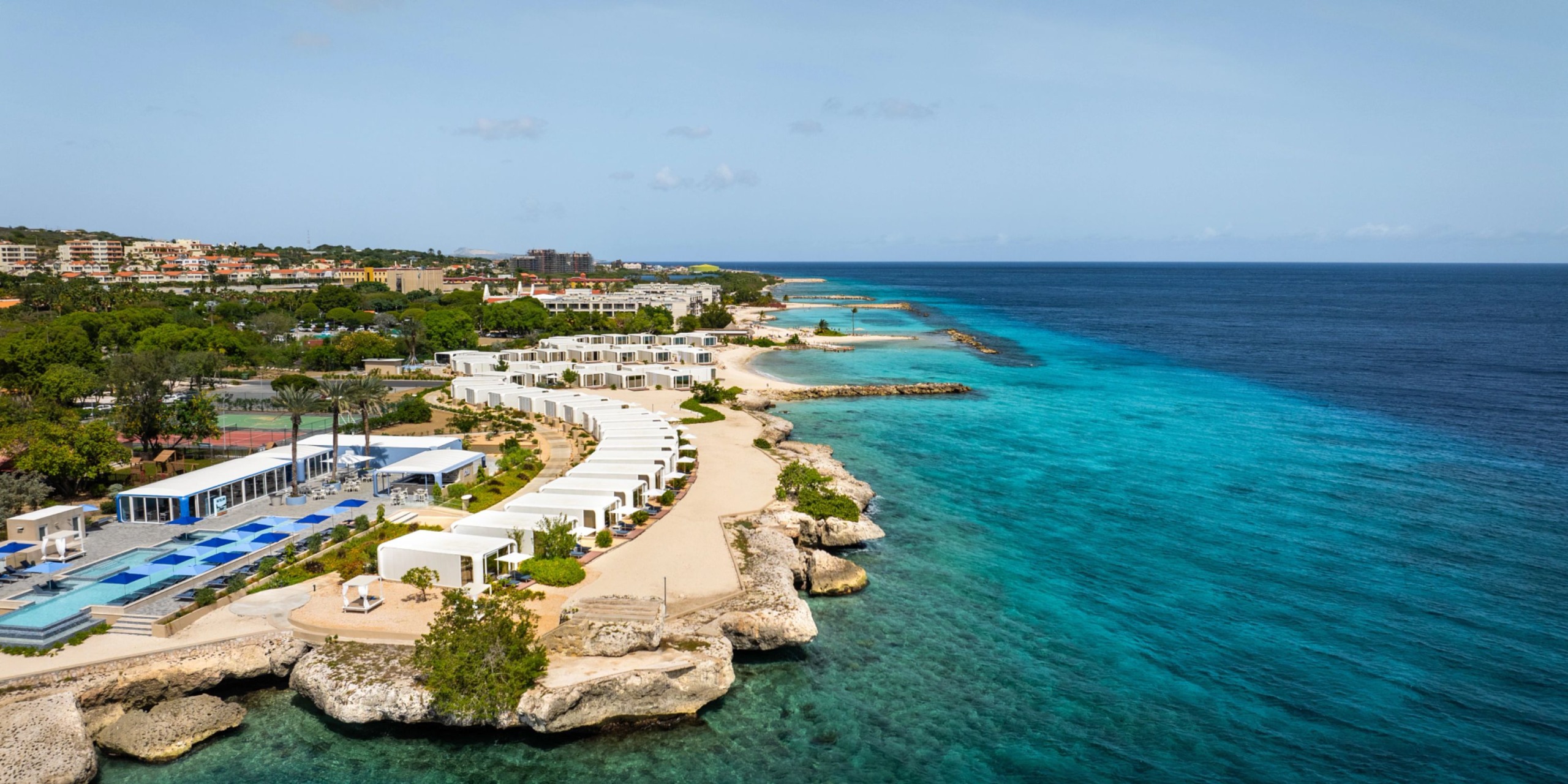 Dreams Curacao features pristine white structures and a swimming pool that offers stunning views of the rocky coastline and crystal-clear turquoise waters.