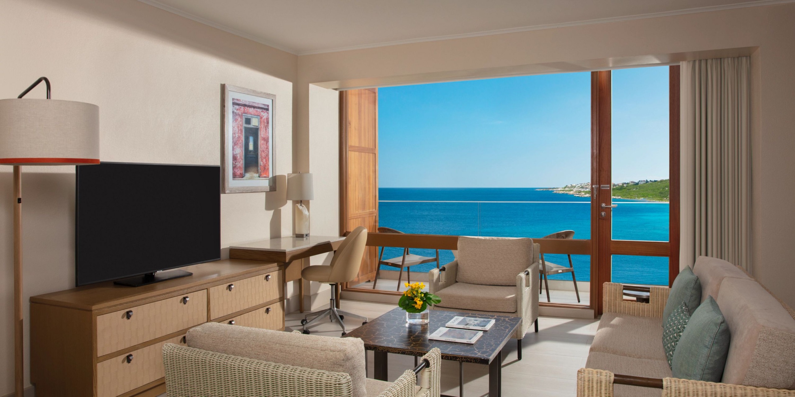 Experience a stay at Dreams Curacao, featuring modern furnishings, a TV, desk, and sofas in your room. Enjoy the large window and door that open to a balcony with breathtaking views of the ocean and coastline.