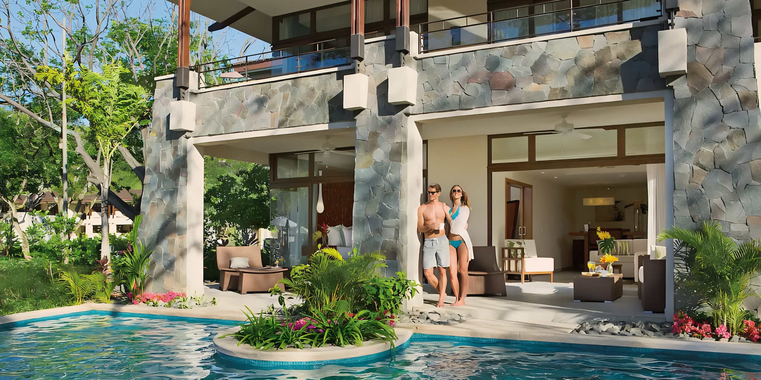 A couple standing by a pool in front of Dreams Las Mareas surrounded by lush greenery.