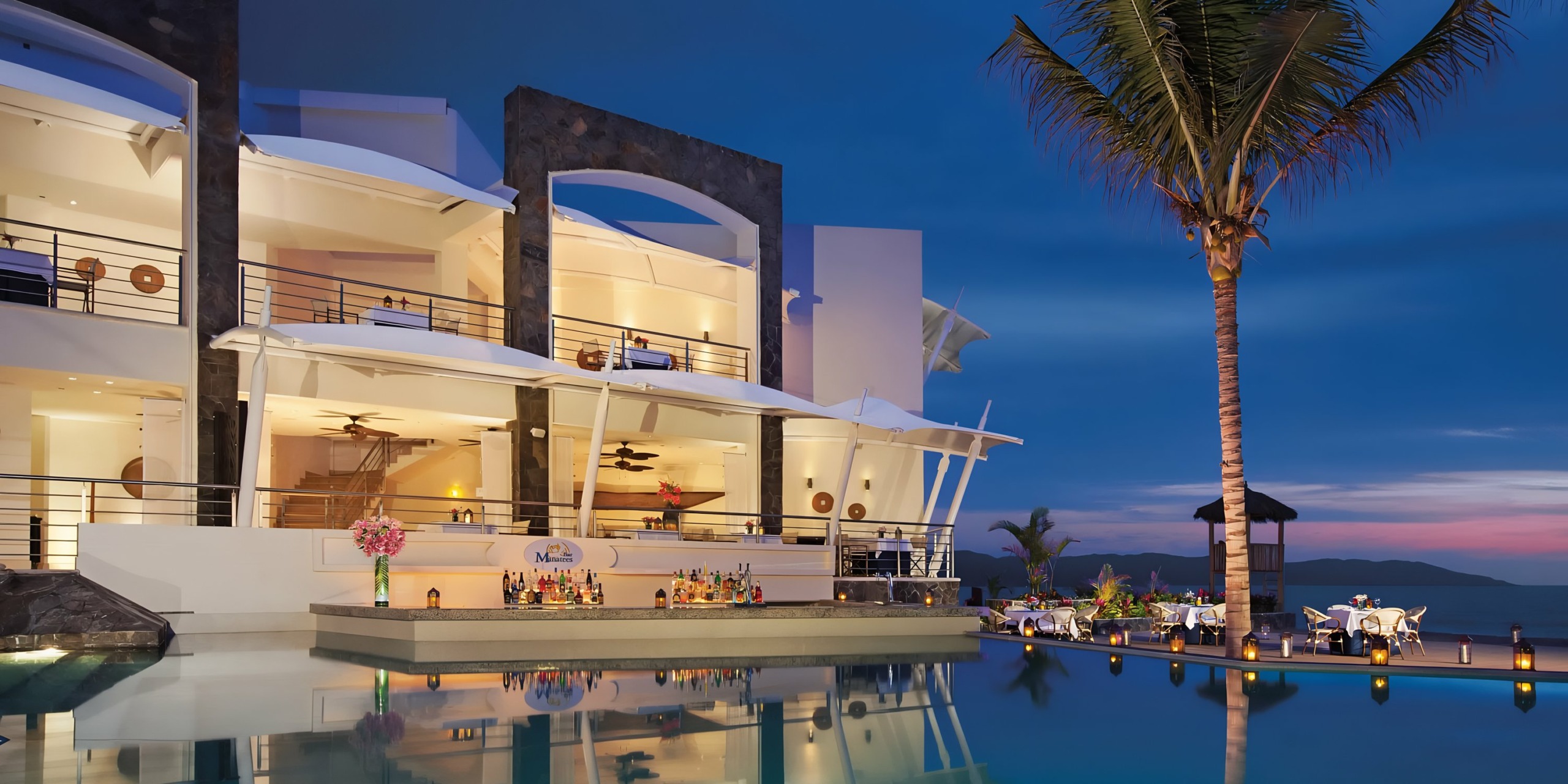 Dreams Vallarta Bay seaside villa with infinity pool and dining area perfect for a wedding at dusk.