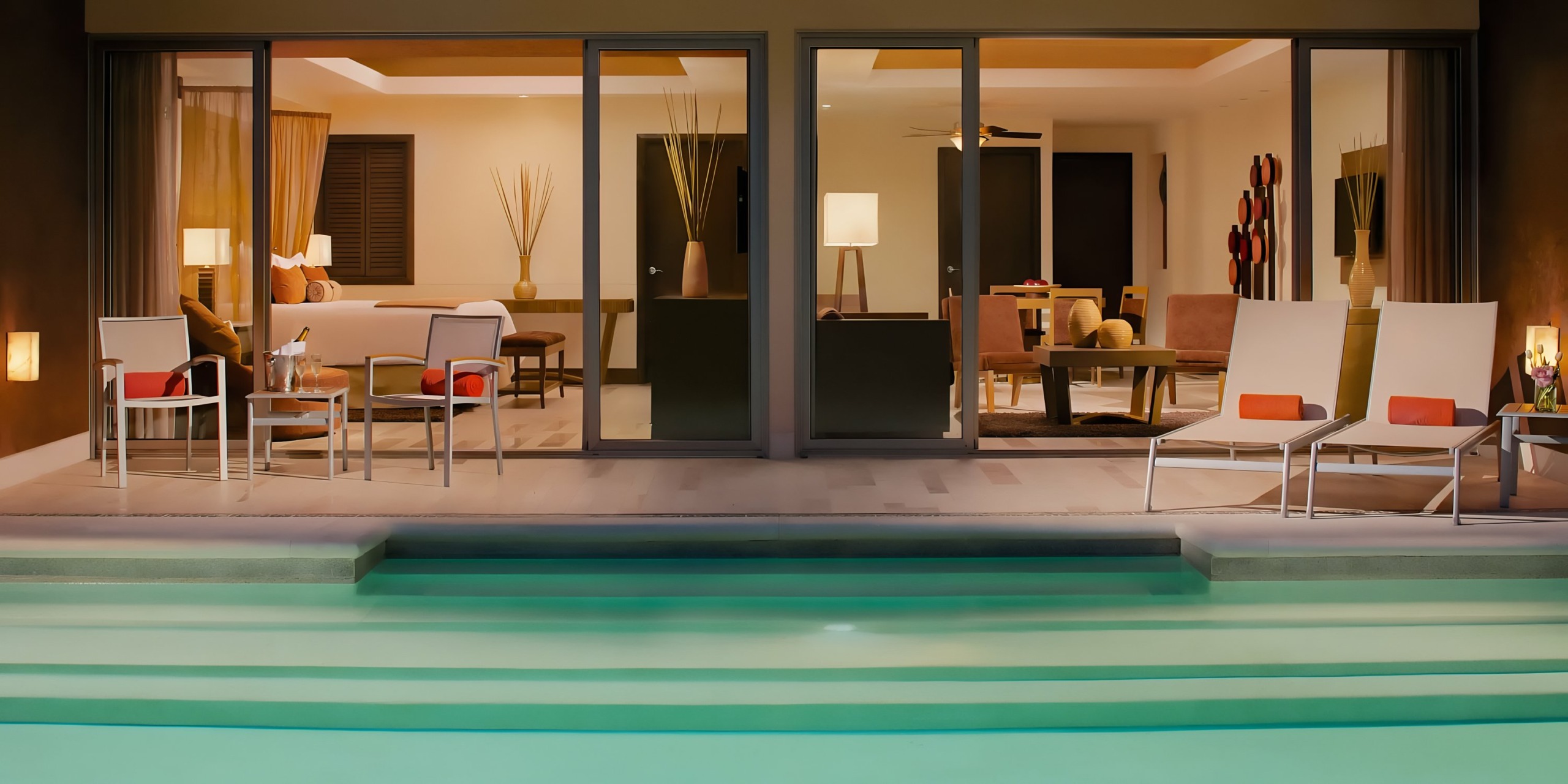 Modern villa with an open living area and poolside patio, perfect for a Dreams Vallarta Bay wedding at dusk.